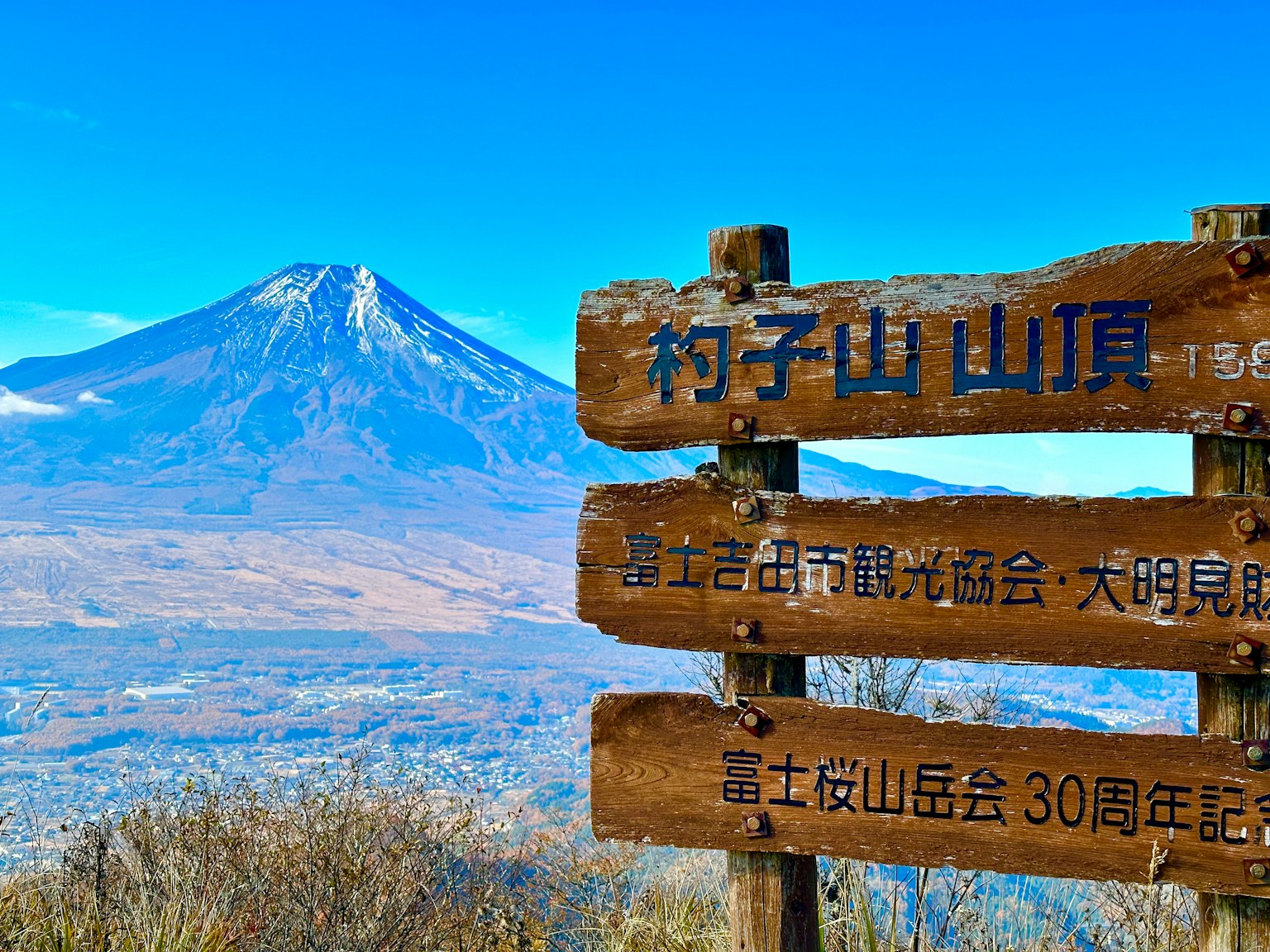 Scenic view of Mount Fuji with wooden signposts