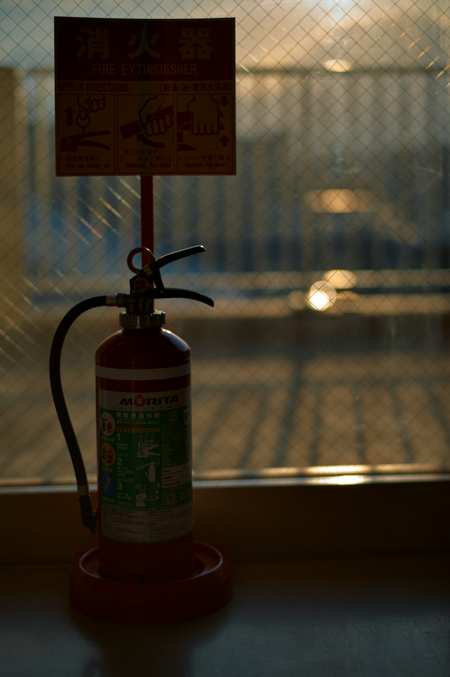 Silhouette of a fire extinguisher with an instructional sign displaying usage guidelines