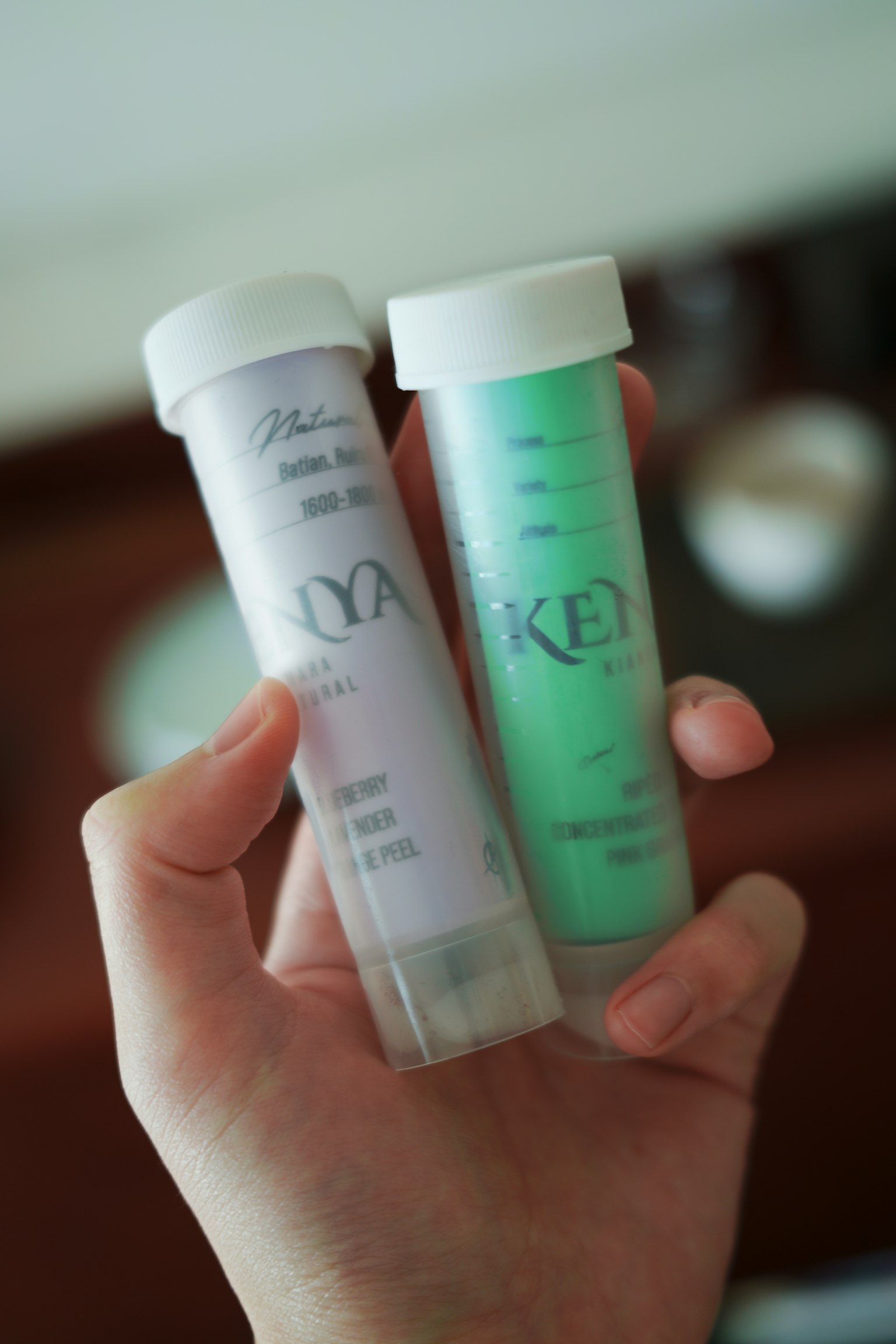 Deux tubes colorés tenus dans une main