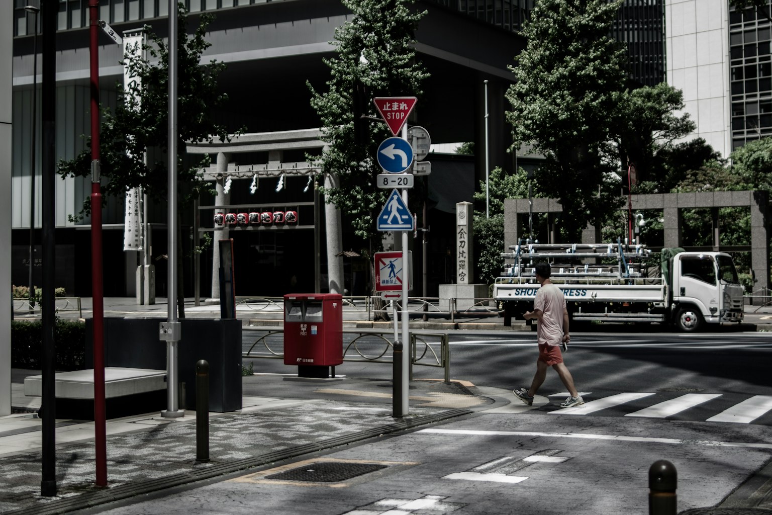 A person crossing the street with urban elements and traffic signs