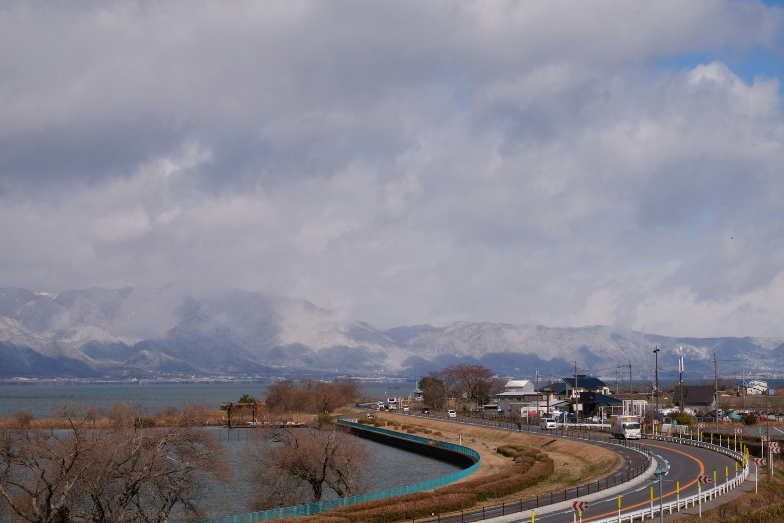 被山脈環繞的湖泊風景 沿水而行的彎曲道路