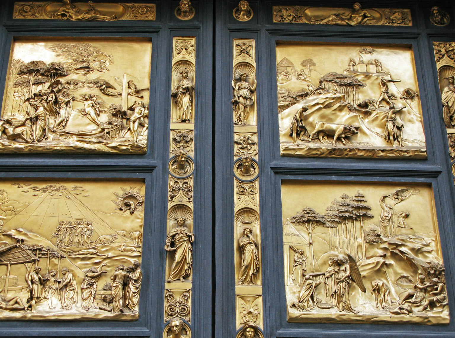Relieves decorativos dorados en puerta azul con escenas intrincadas
