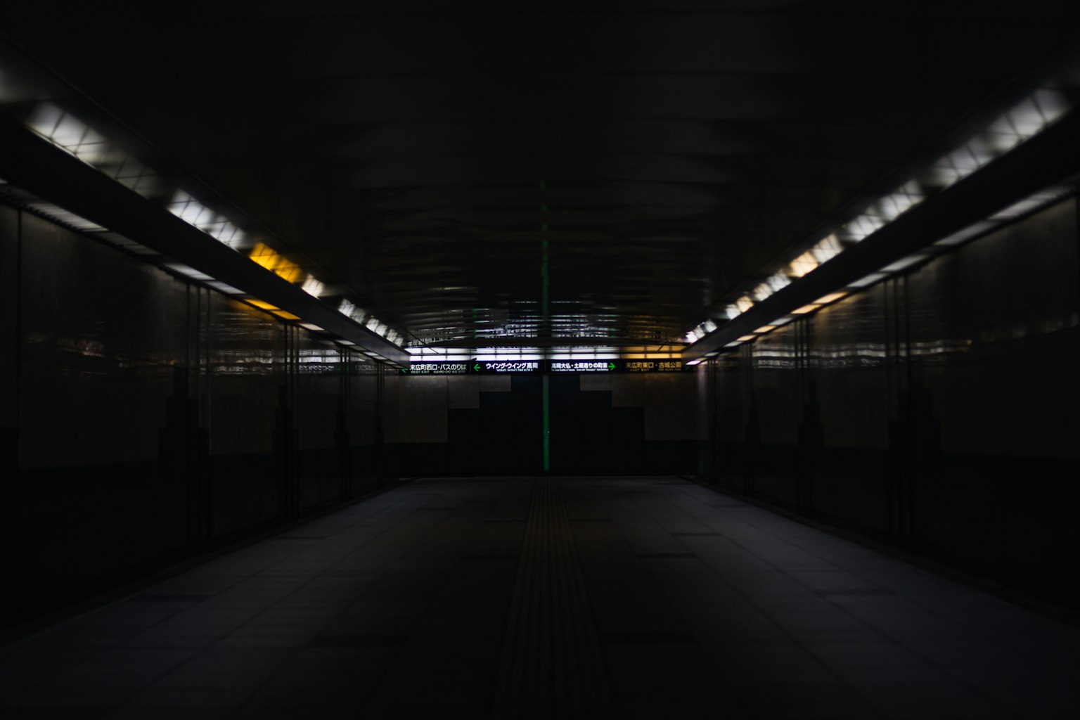 暗いトンネルの内部にある光のラインと反射