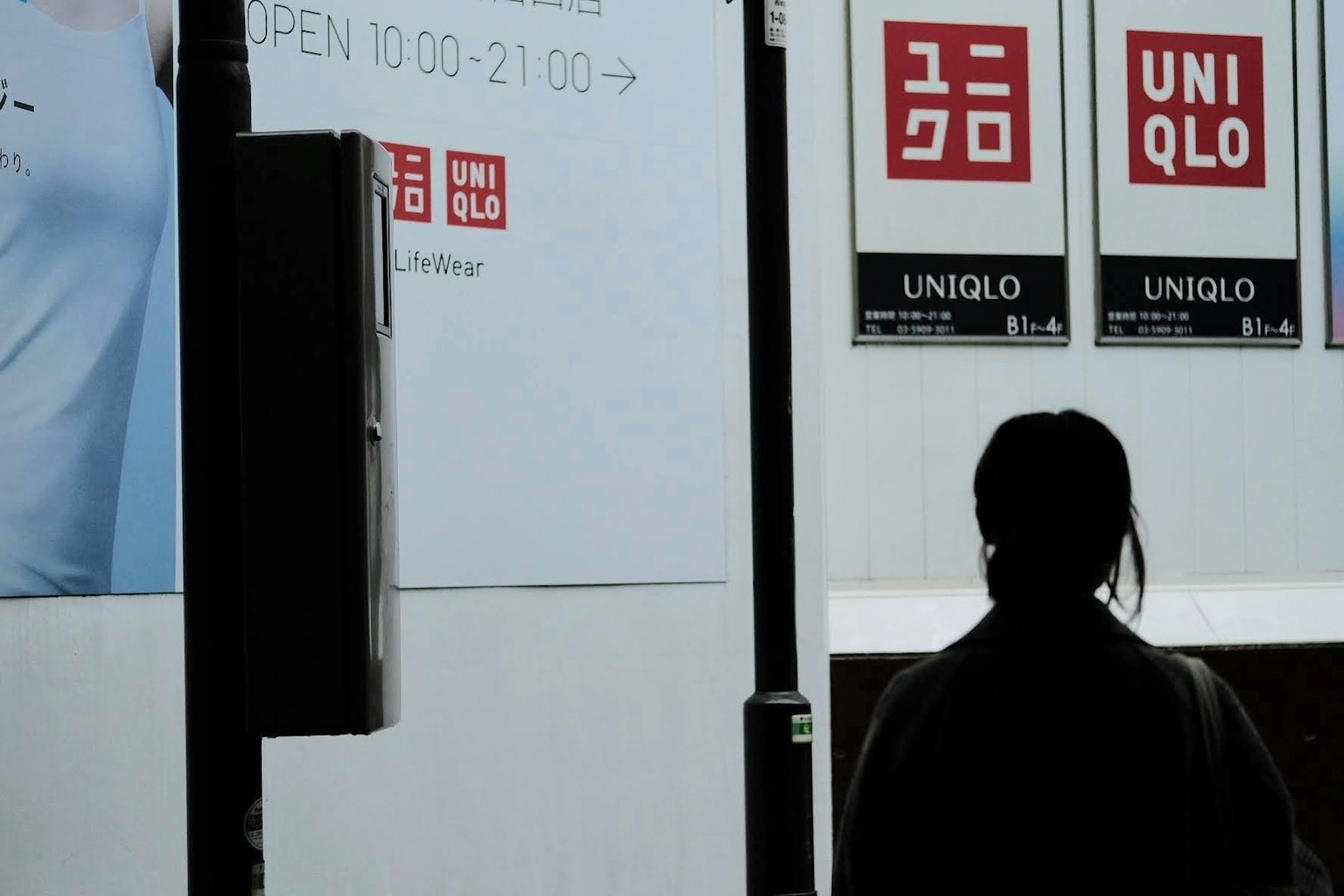 UNIQLO 간판을 배경으로 한 인물의 실루엣