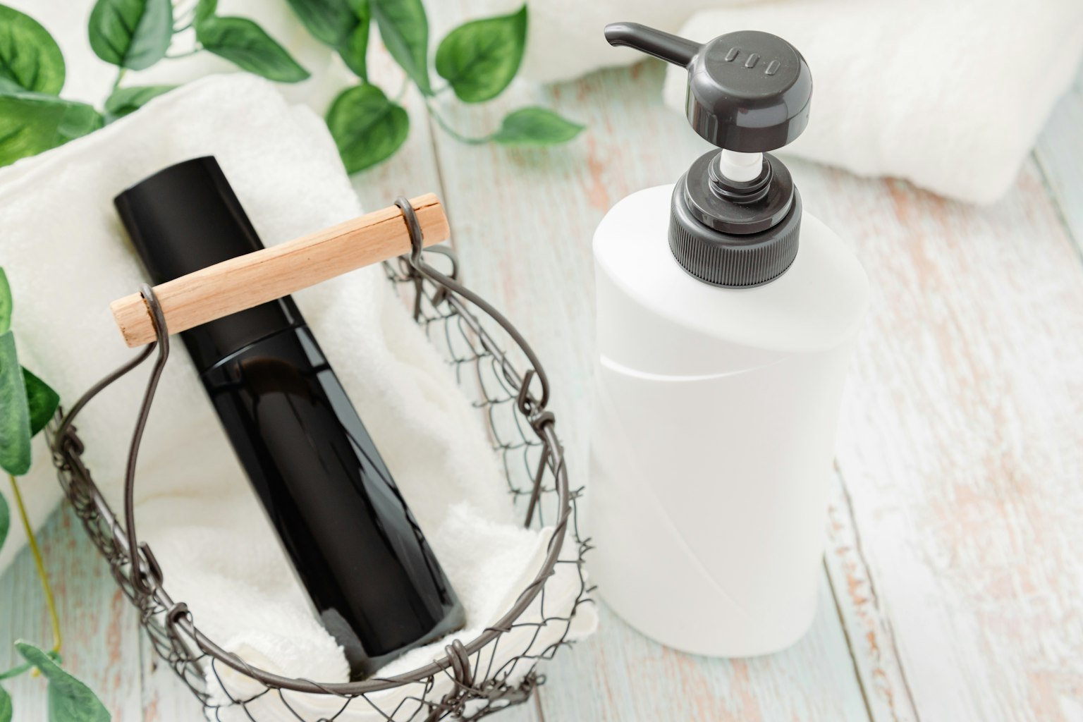 Sebuah botol hitam dan botol pompa putih ditempatkan di dalam keranjang
