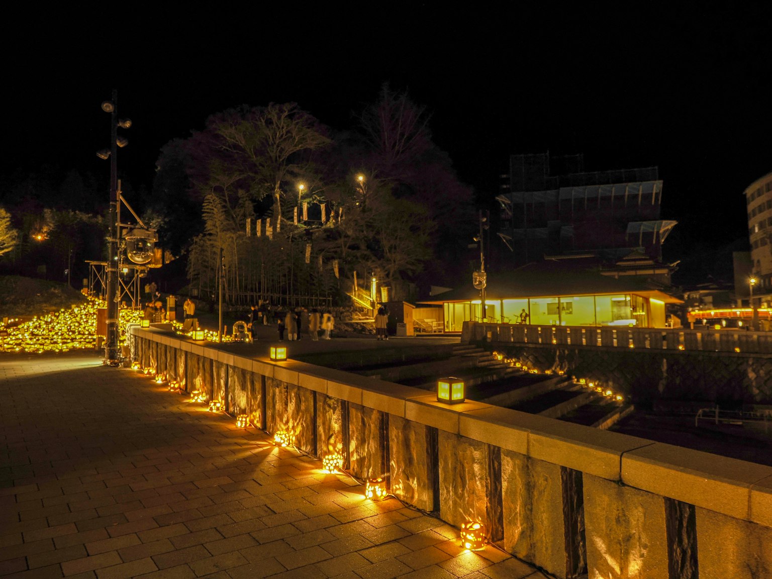สะพานสวยงามที่มีแสงไฟในยามค่ำคืนพร้อมทิวทัศน์รอบๆ