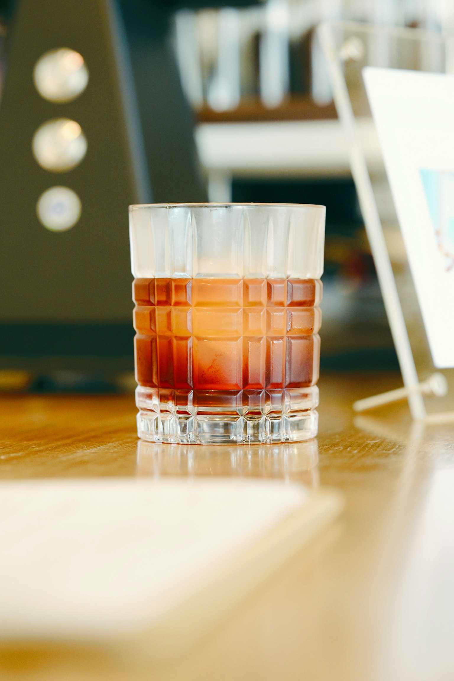 Ein Cocktail in einem klaren Glas auf einem Holztisch