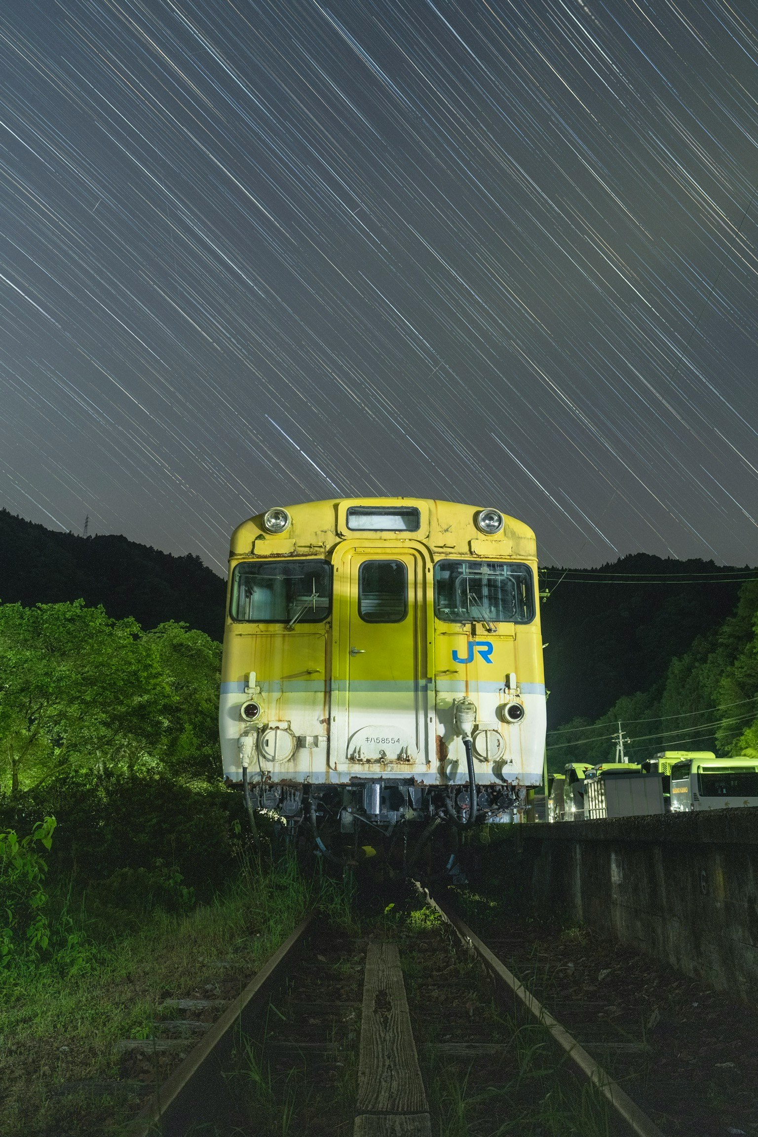 El tren KiHa 58 × Startrail detenido sobre las vías en la estación de Annohana bajo un cielo estrellado