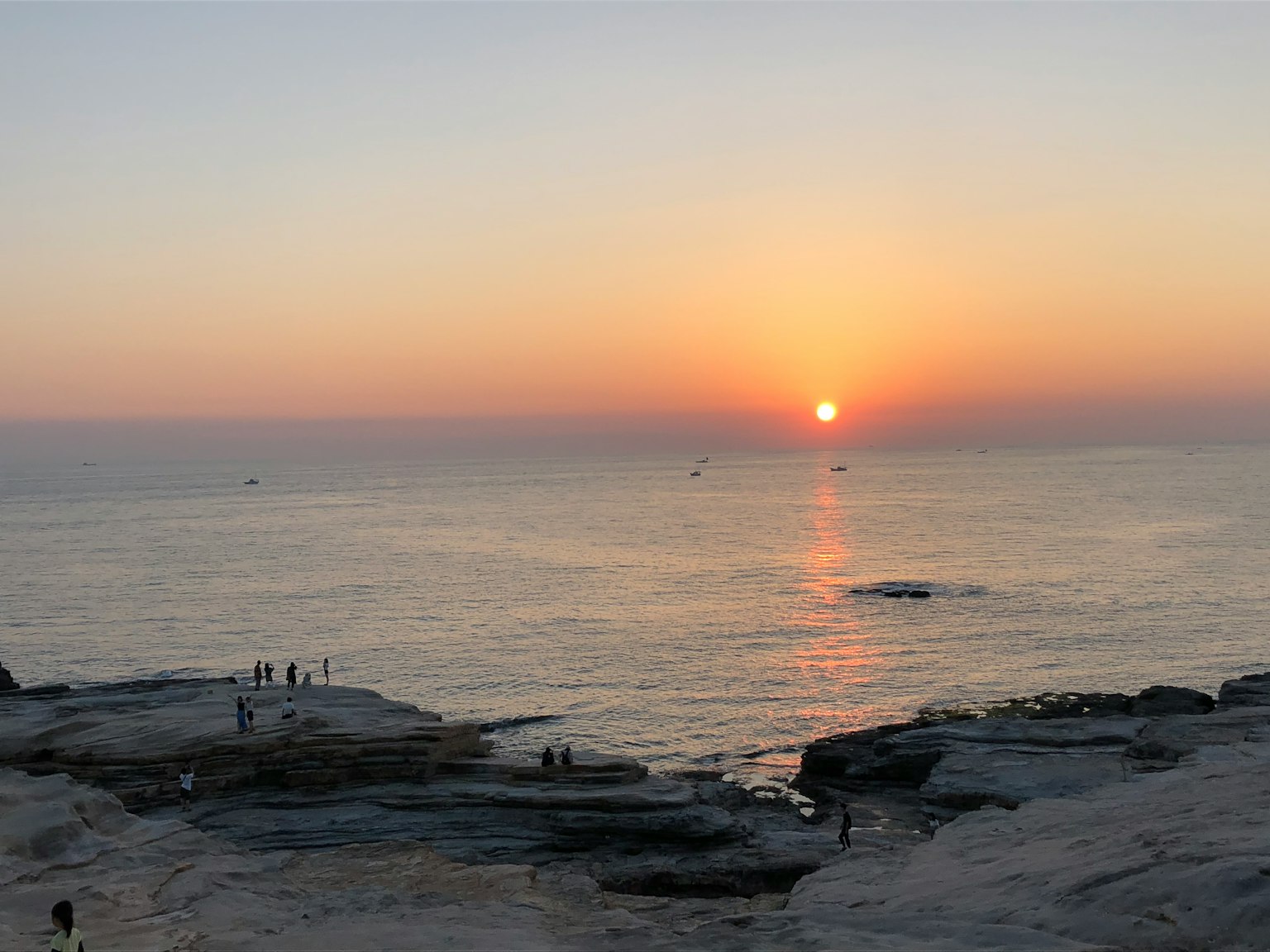 Splendida vista del tramonto sul mare con persone sulle rocce