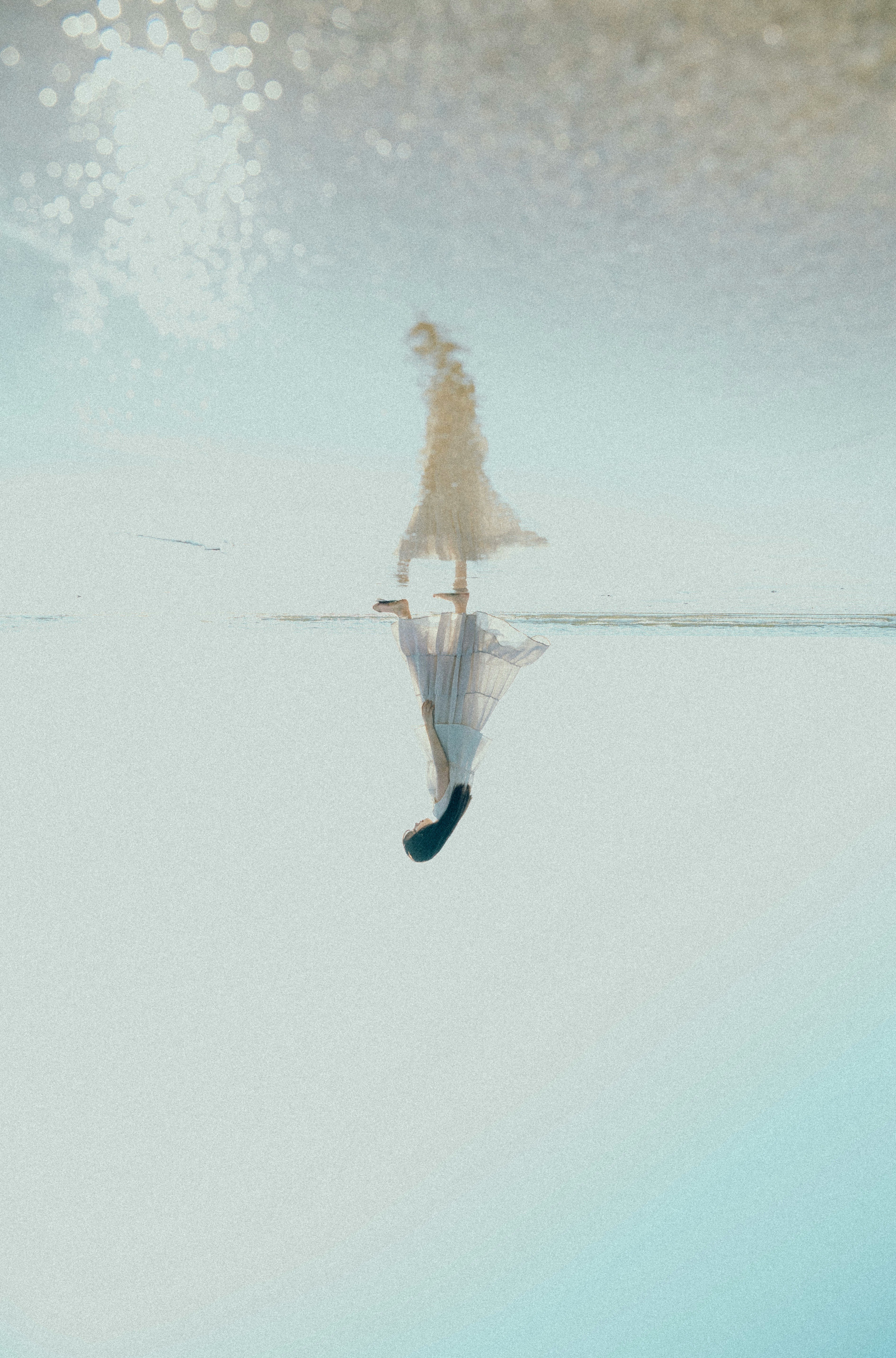鏡の海に浮かぶ人物のシルエット