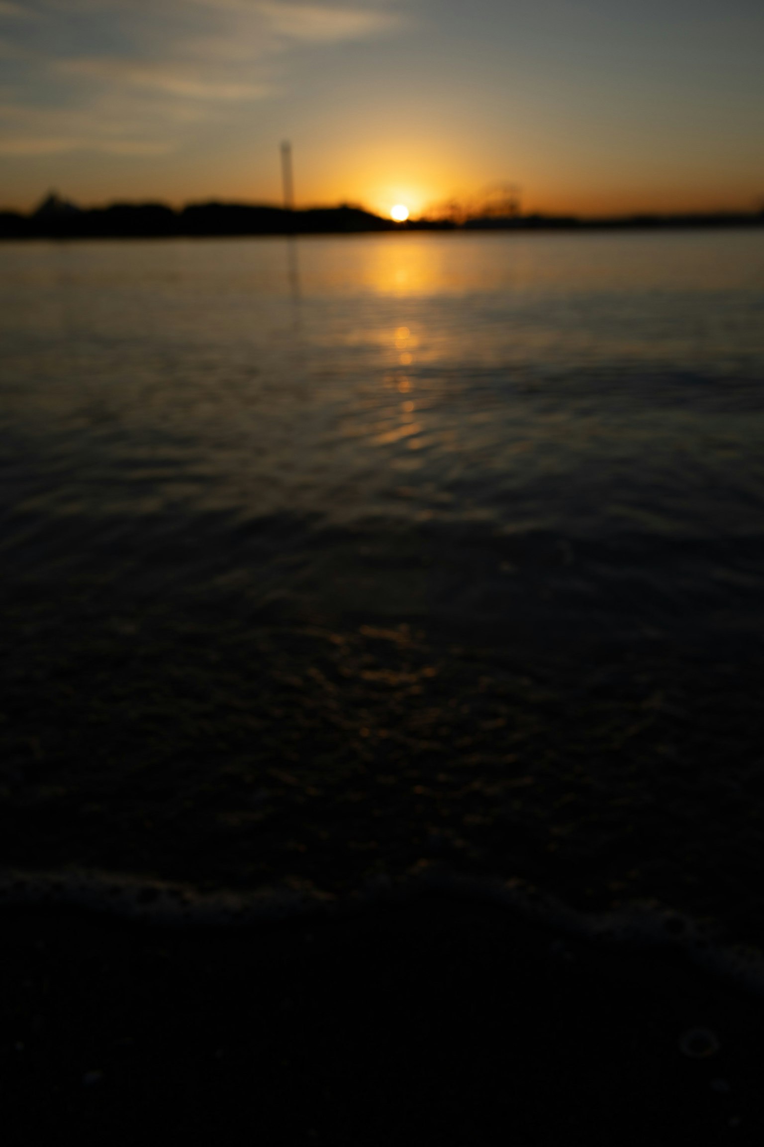 Ruhige Seesicht mit Sonnenuntergang, der sich im Wasser spiegelt