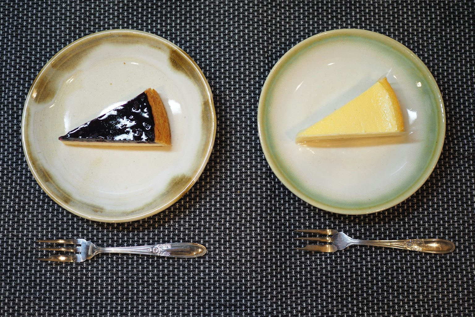 Deux assiettes avec une part de gâteau noir et une part de gâteau jaune