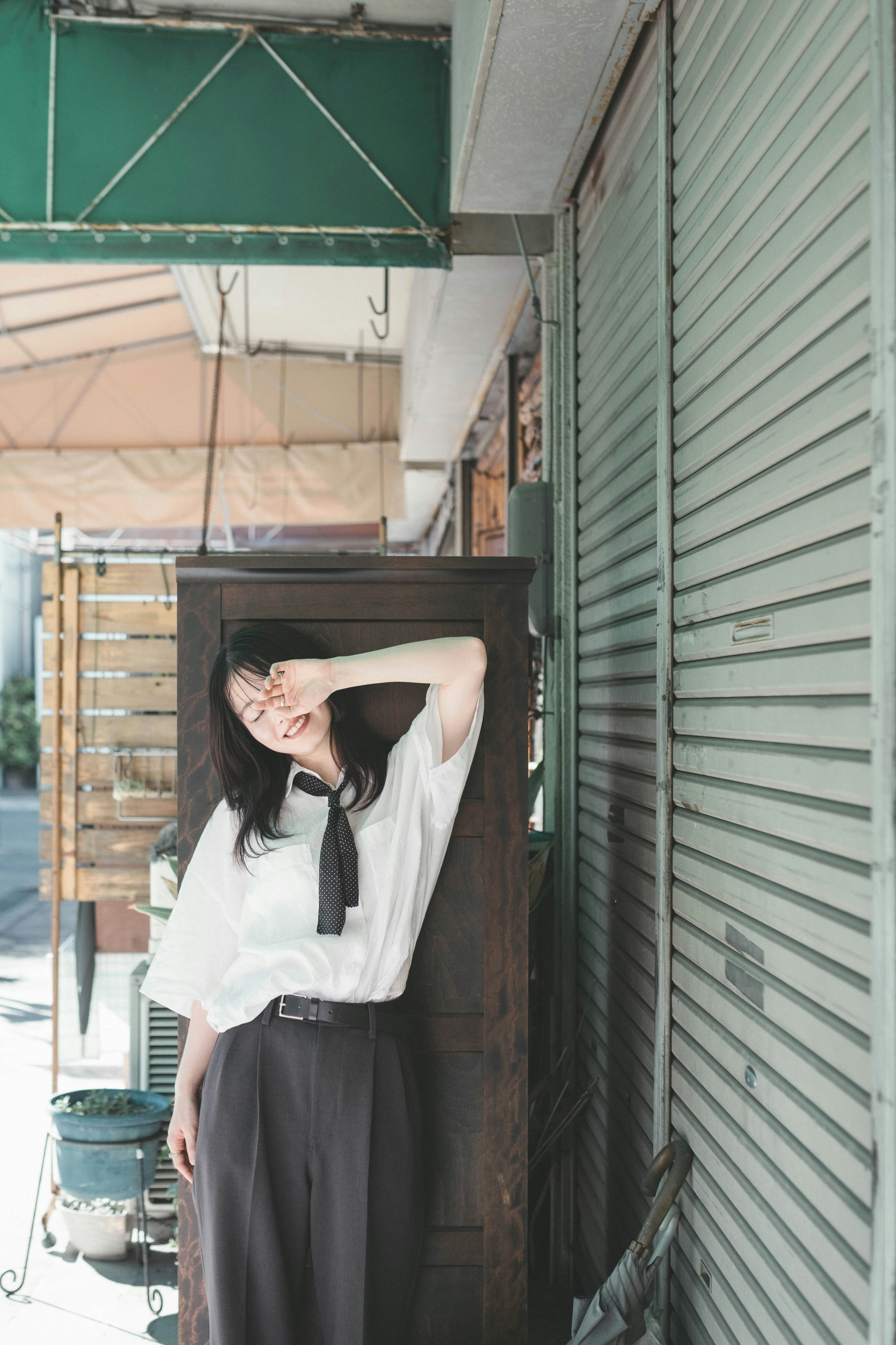 巷弄屋簷下擺姿勢的女性