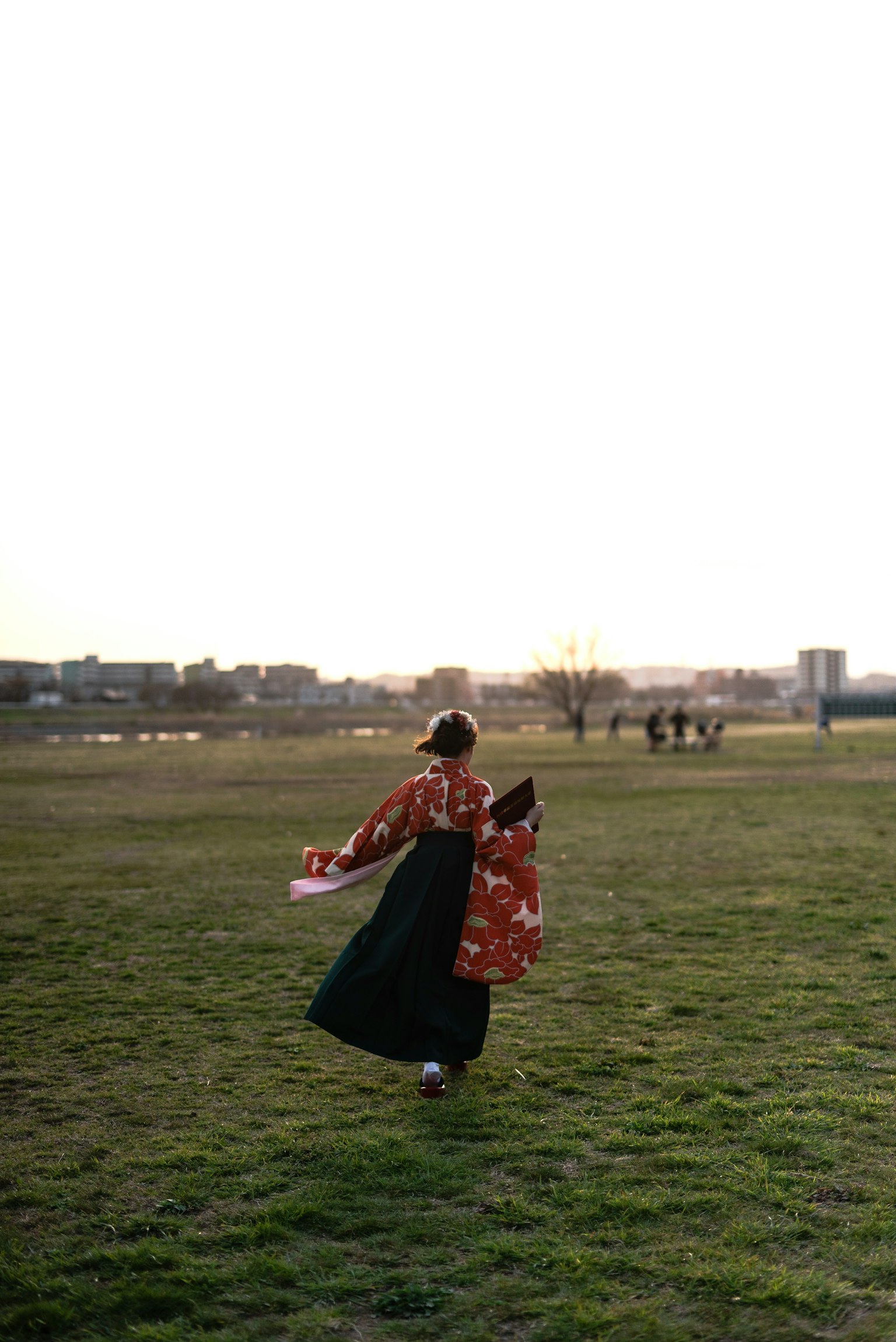 Donna in kimono tradizionale che corre in un campo