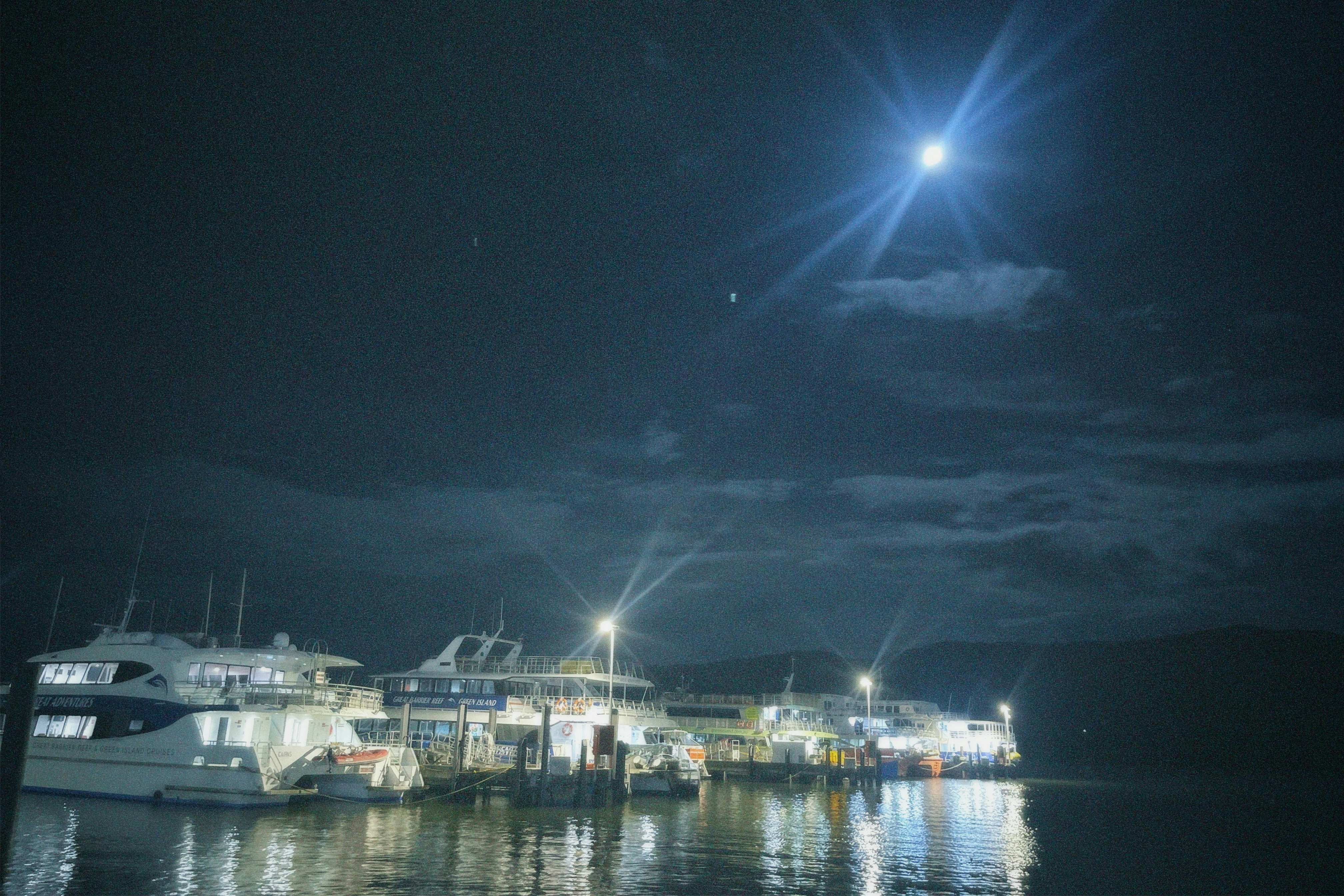 オーストラリアの夜の港に停泊する船と水面の光