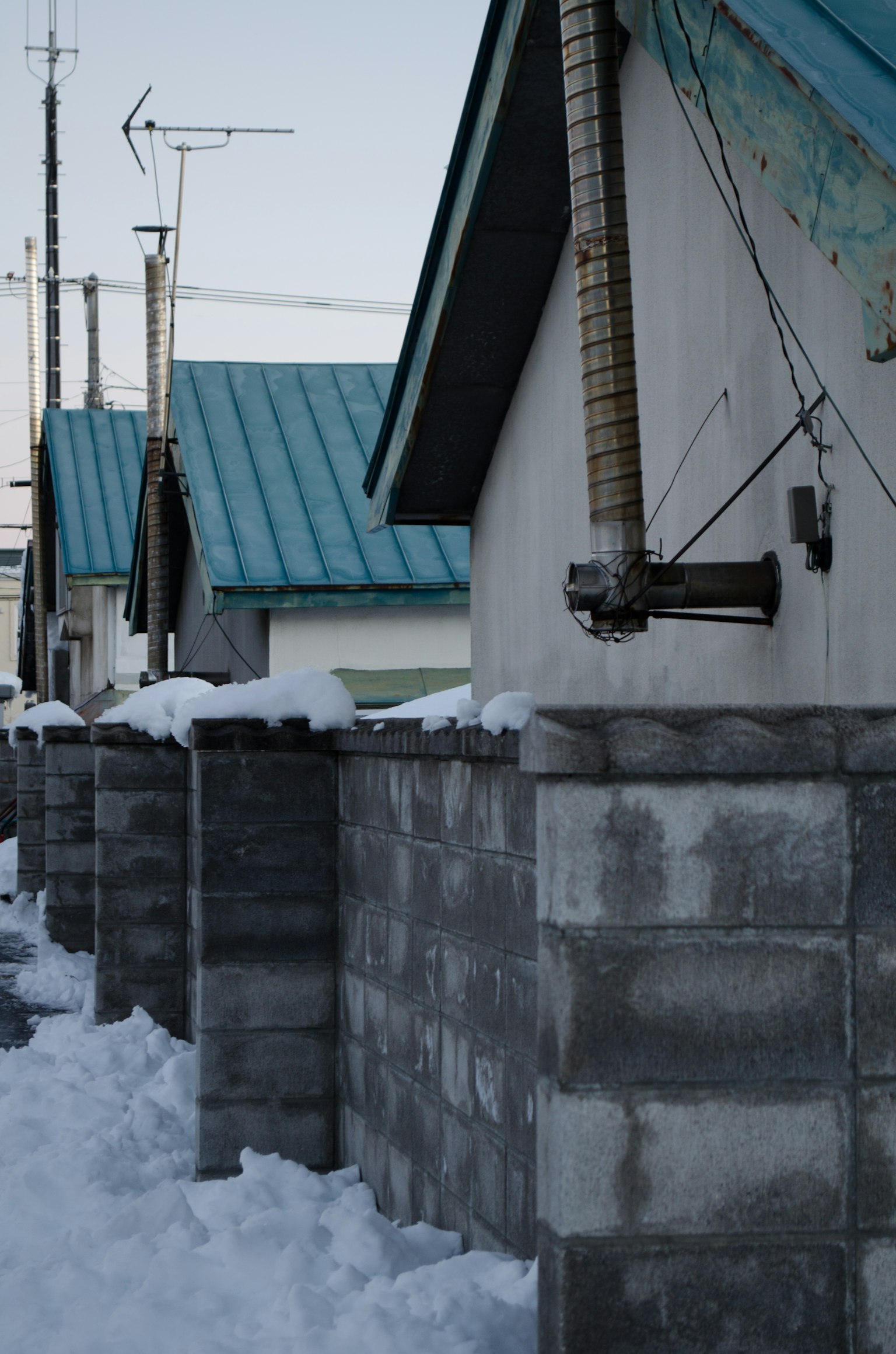 Mur en blocs recouvert de neige avec des maisons aux toits bleus