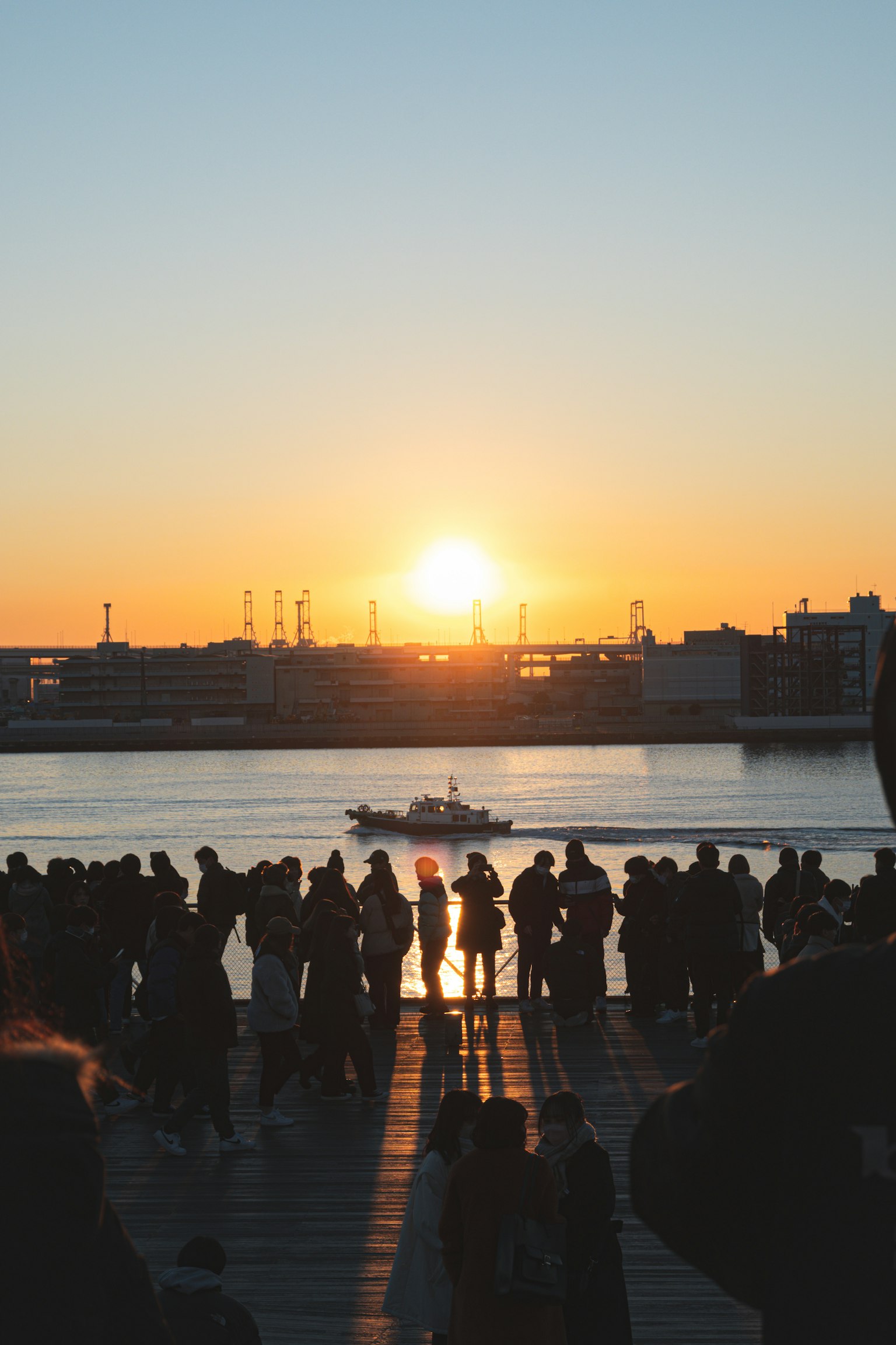 Silhouette di persone contro un tramonto su un fiume