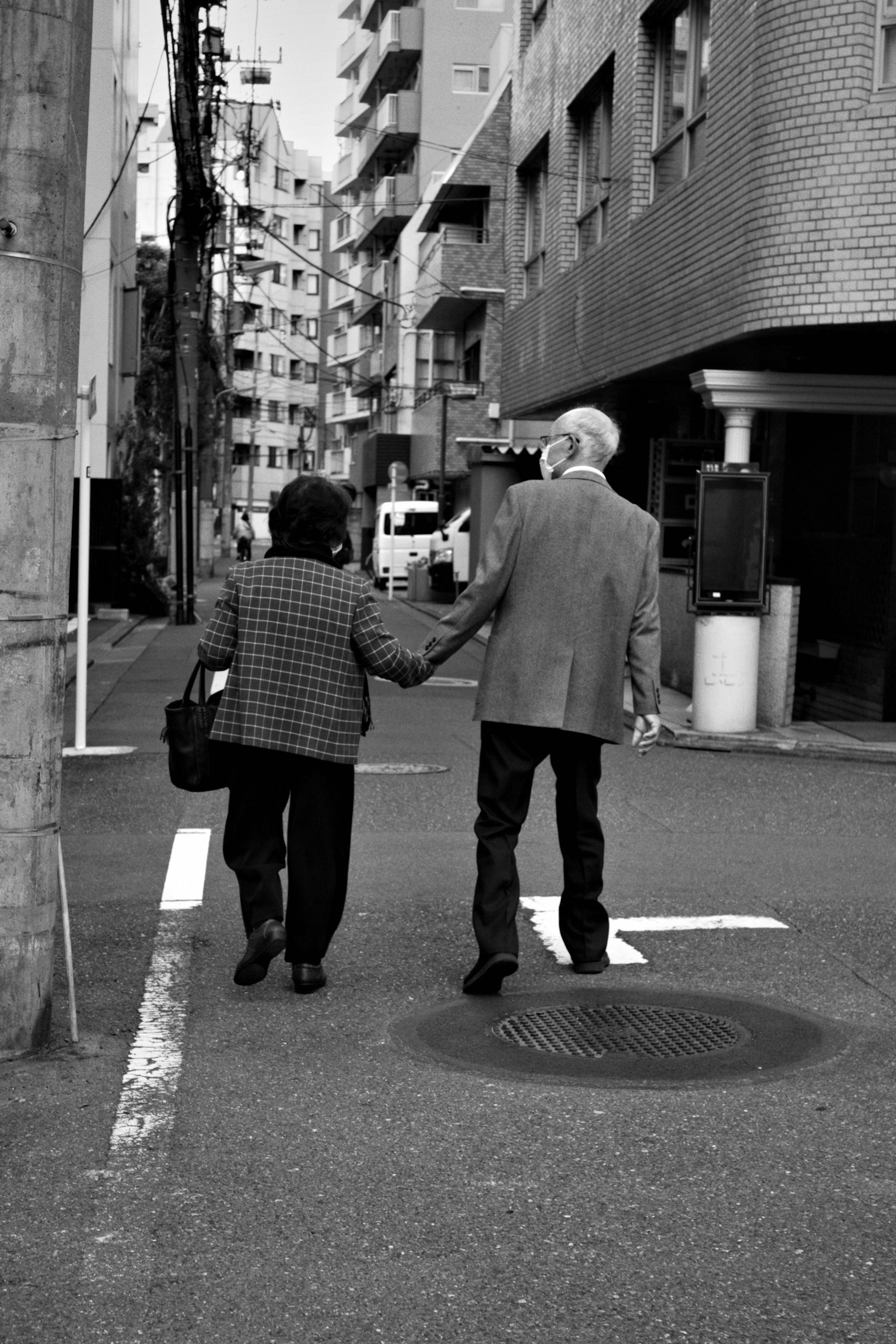 在城市街道上手牵手散步的老年夫妇