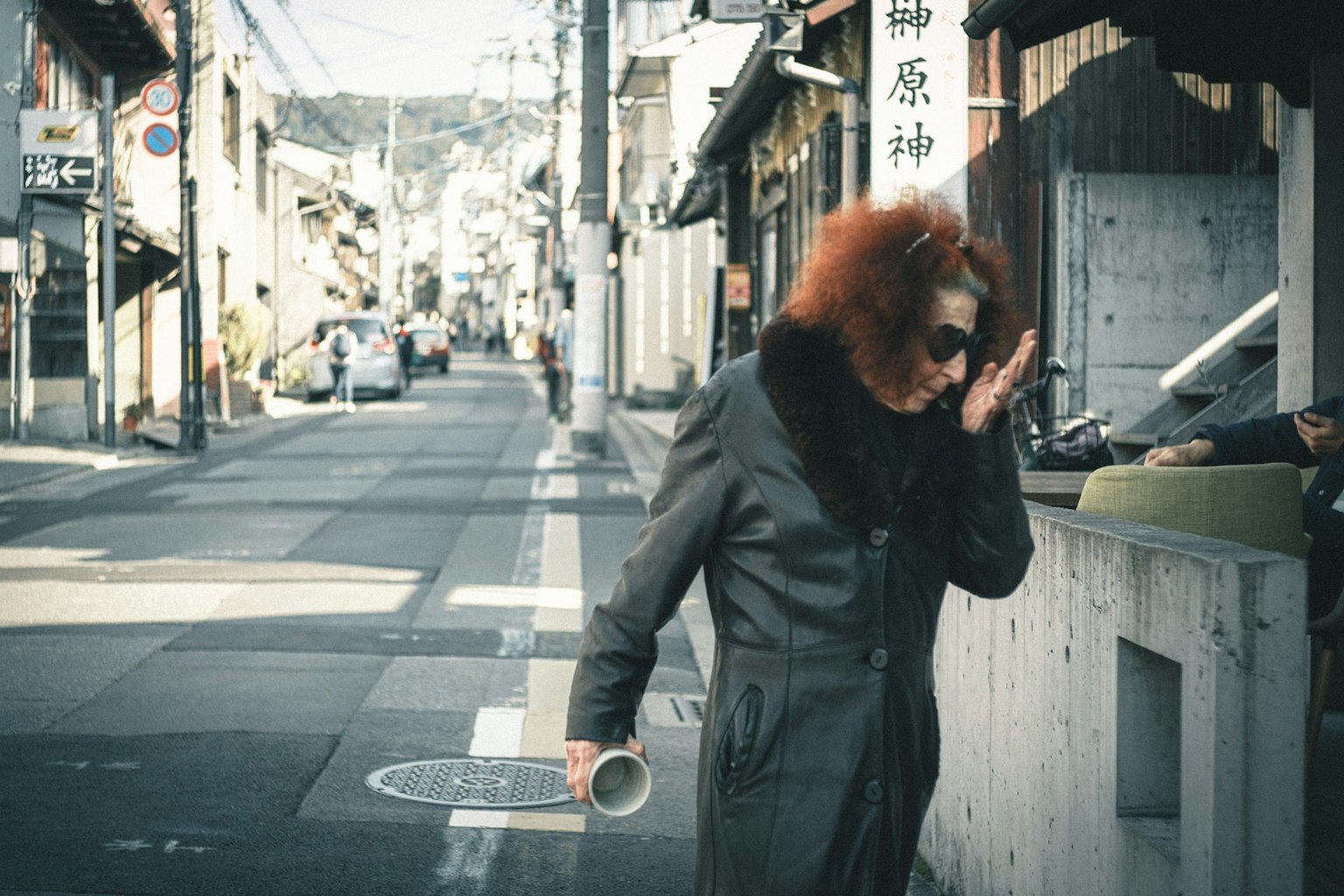 Una mujer con cabello rojo caminando por una calle