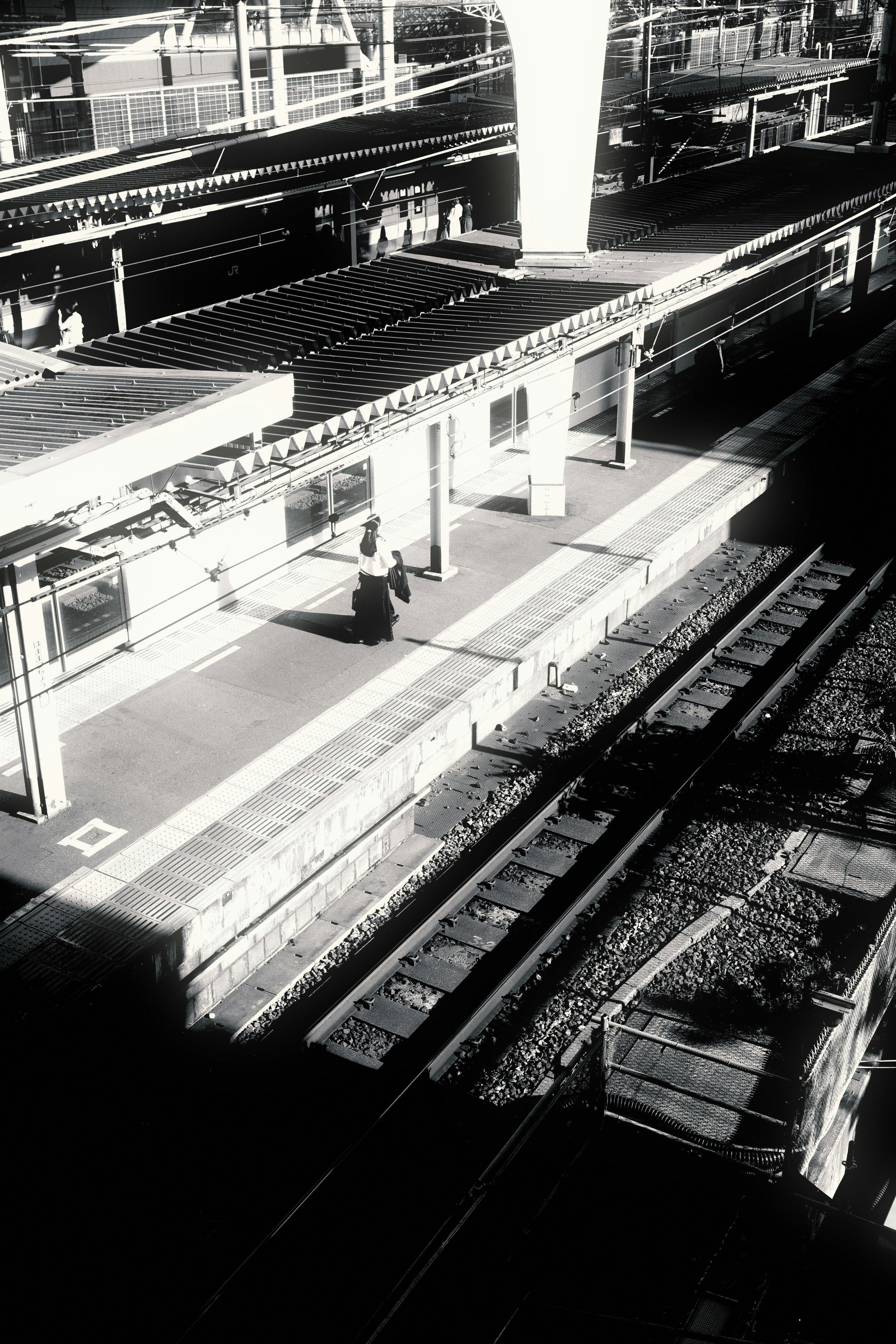 Street snap en noir et blanc surplombant les quais et les voies de la gare de Hamamatsuchō