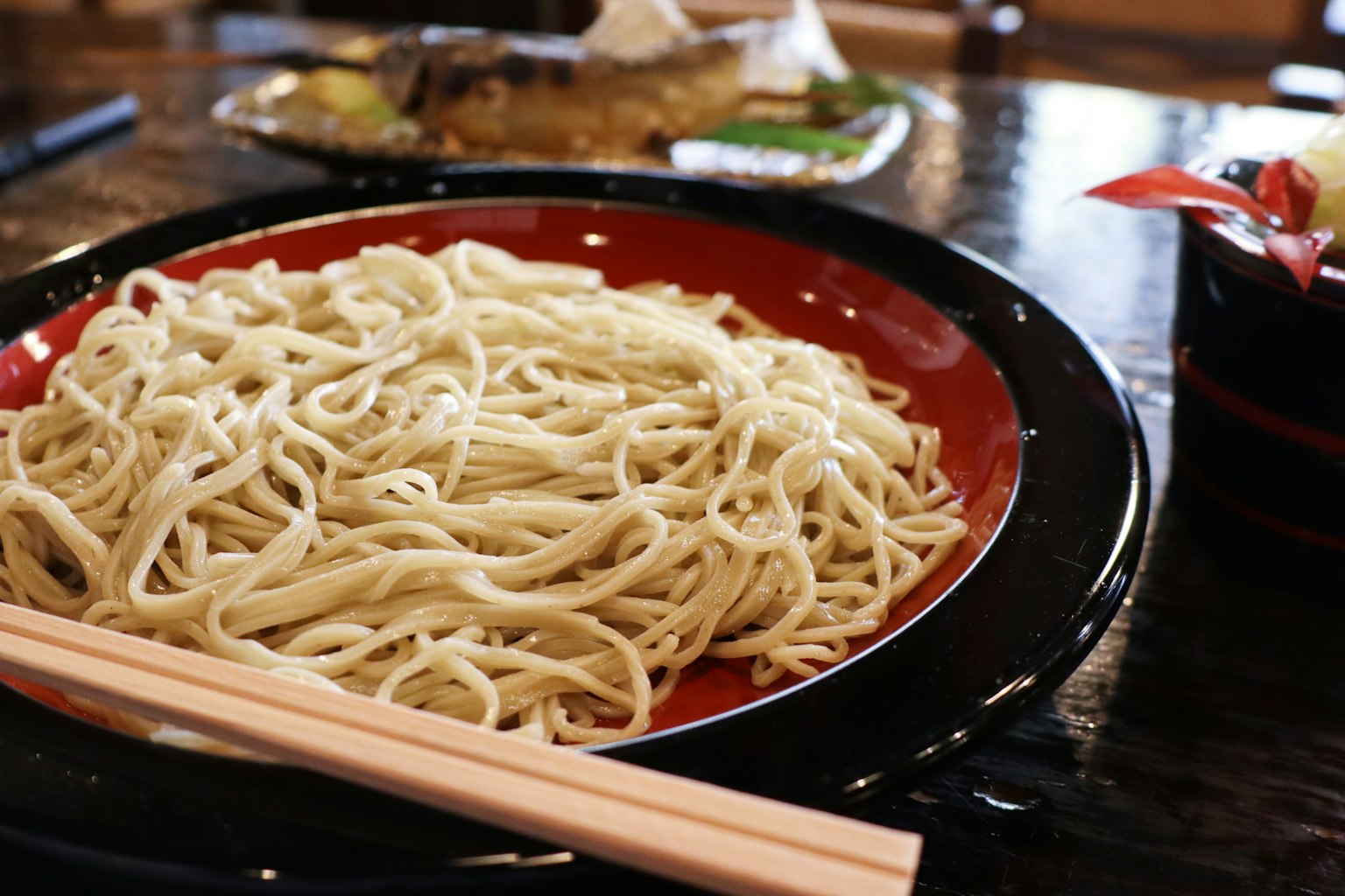 맛있는 소바 면이 검은 그릇에 담겨 있고 젓가락이 있다