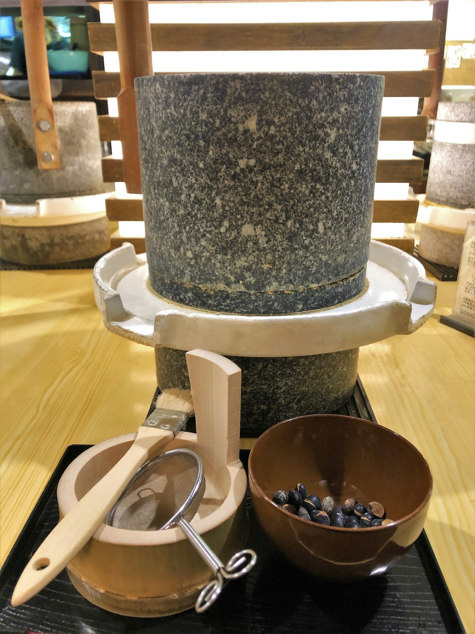 Un mortaio in pietra blu con strumenti in legno accanto