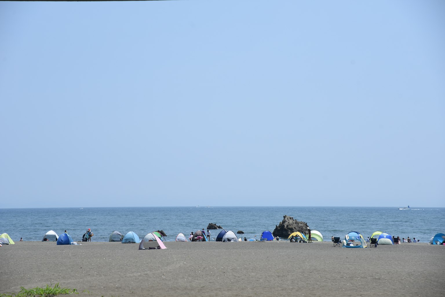 Parasols colorés alignés sur une plage avec une mer calme