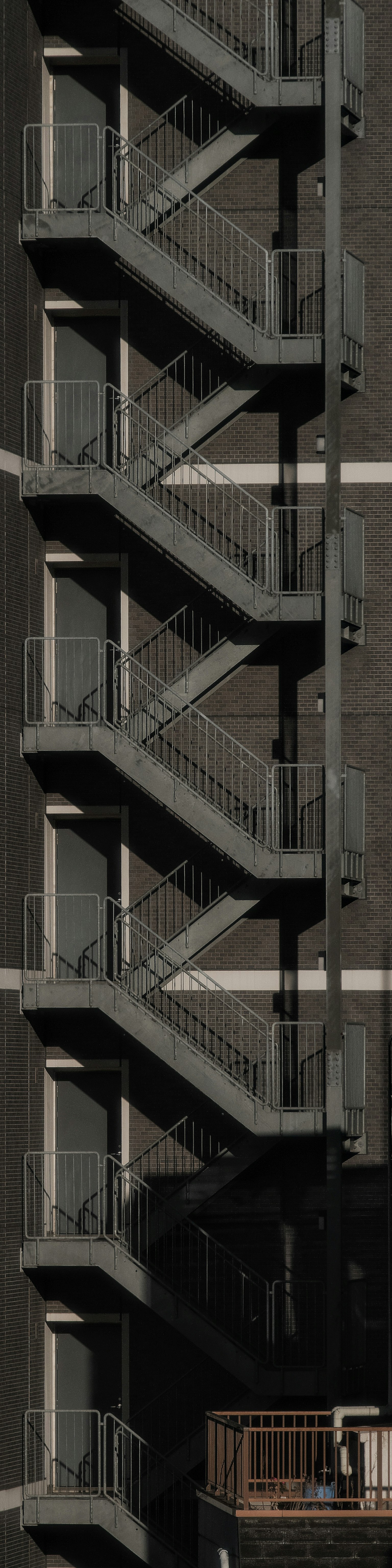 Metal spiral staircase attached to a building with a dark exterior