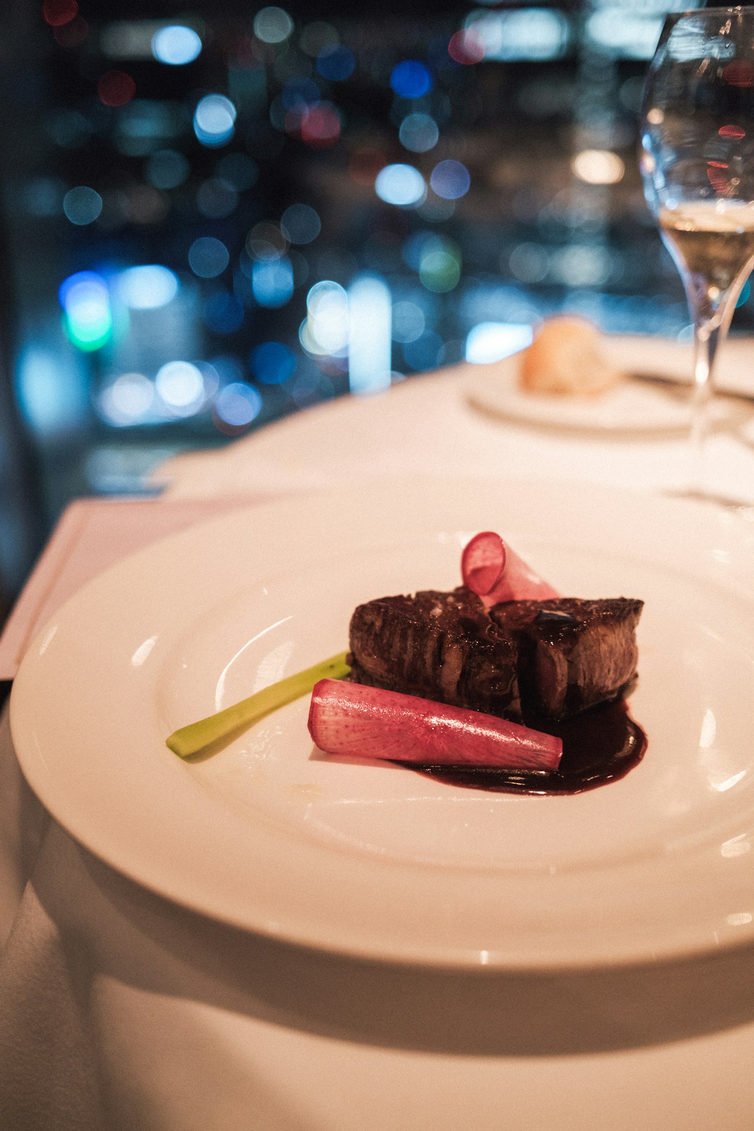 Un filet di manzo splendidamente impiattato con salsa di cipolla rossa e guarnizione verde