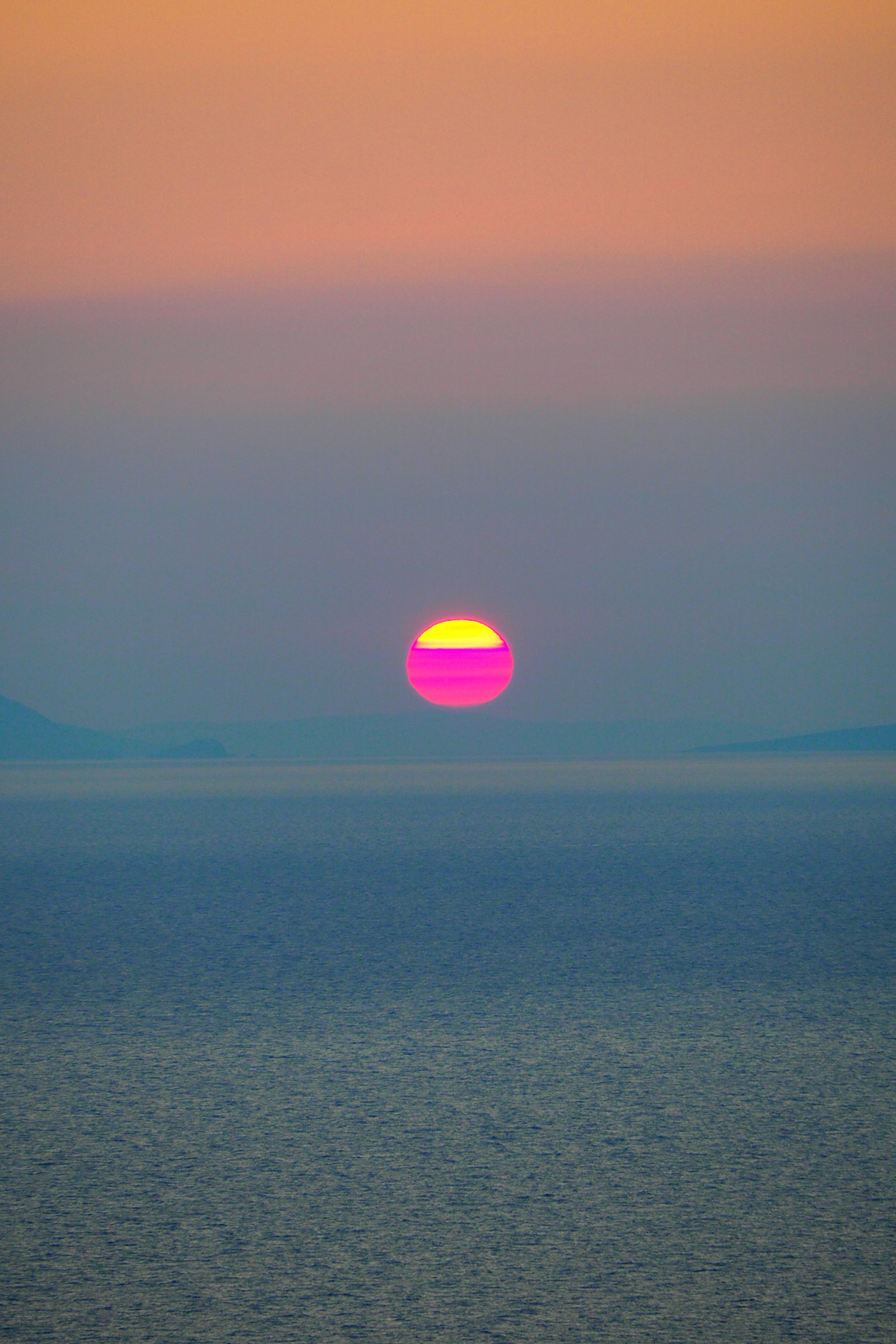 Vibrant pink and orange sunset over the ocean