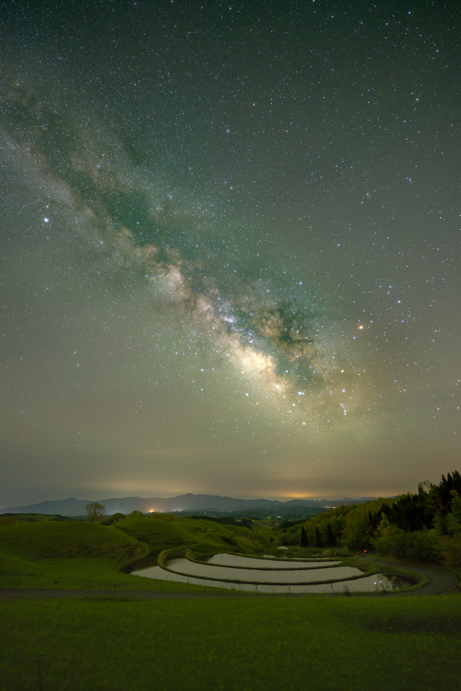 Stunning view of the Milky Way over green hills at night