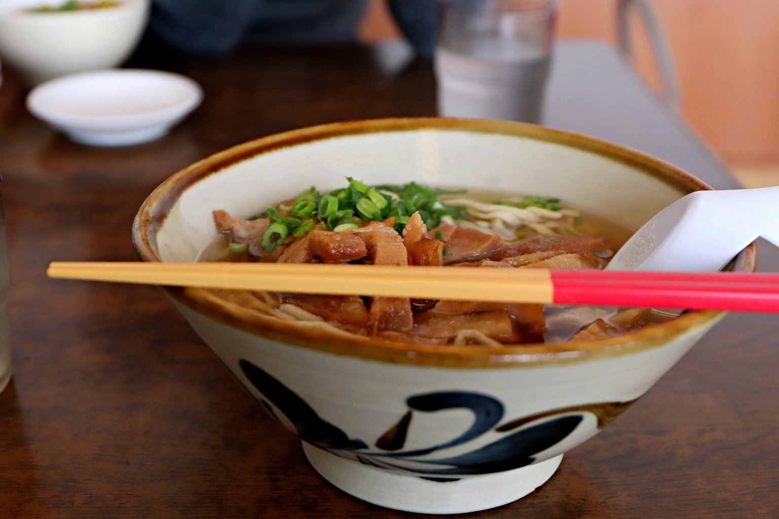 Tazón de ramen delicioso con palillos rojos y cebollín como cobertura