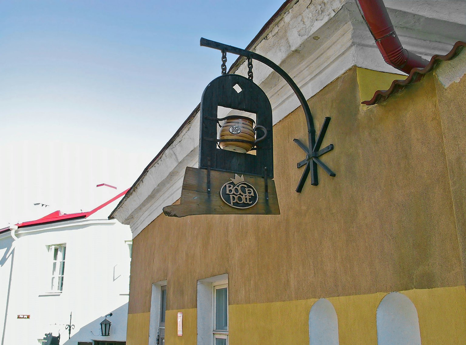 Cartel en forma de campana de metal colgado afuera de un edificio