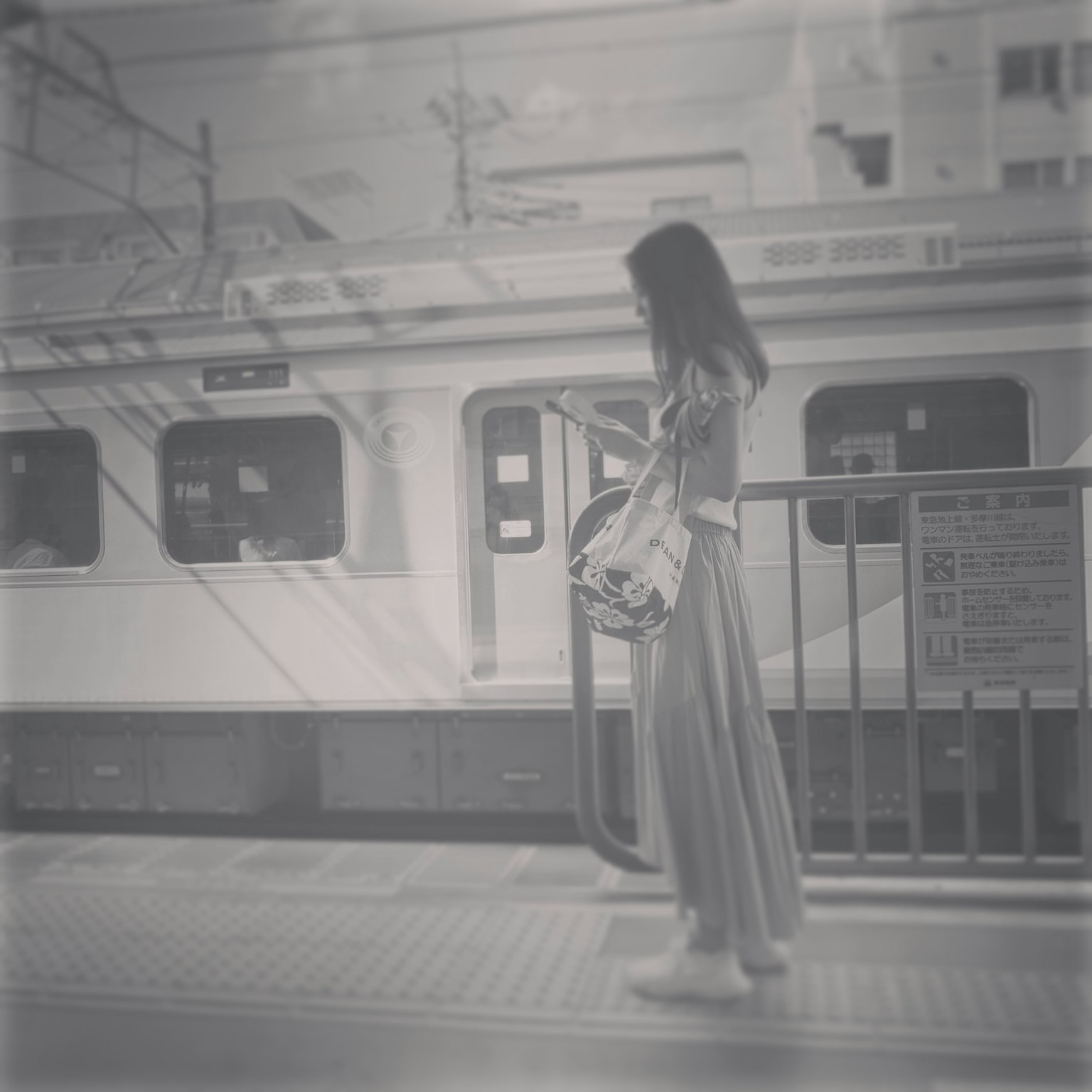 一位穿着长裙的女性在黑白火车站等候