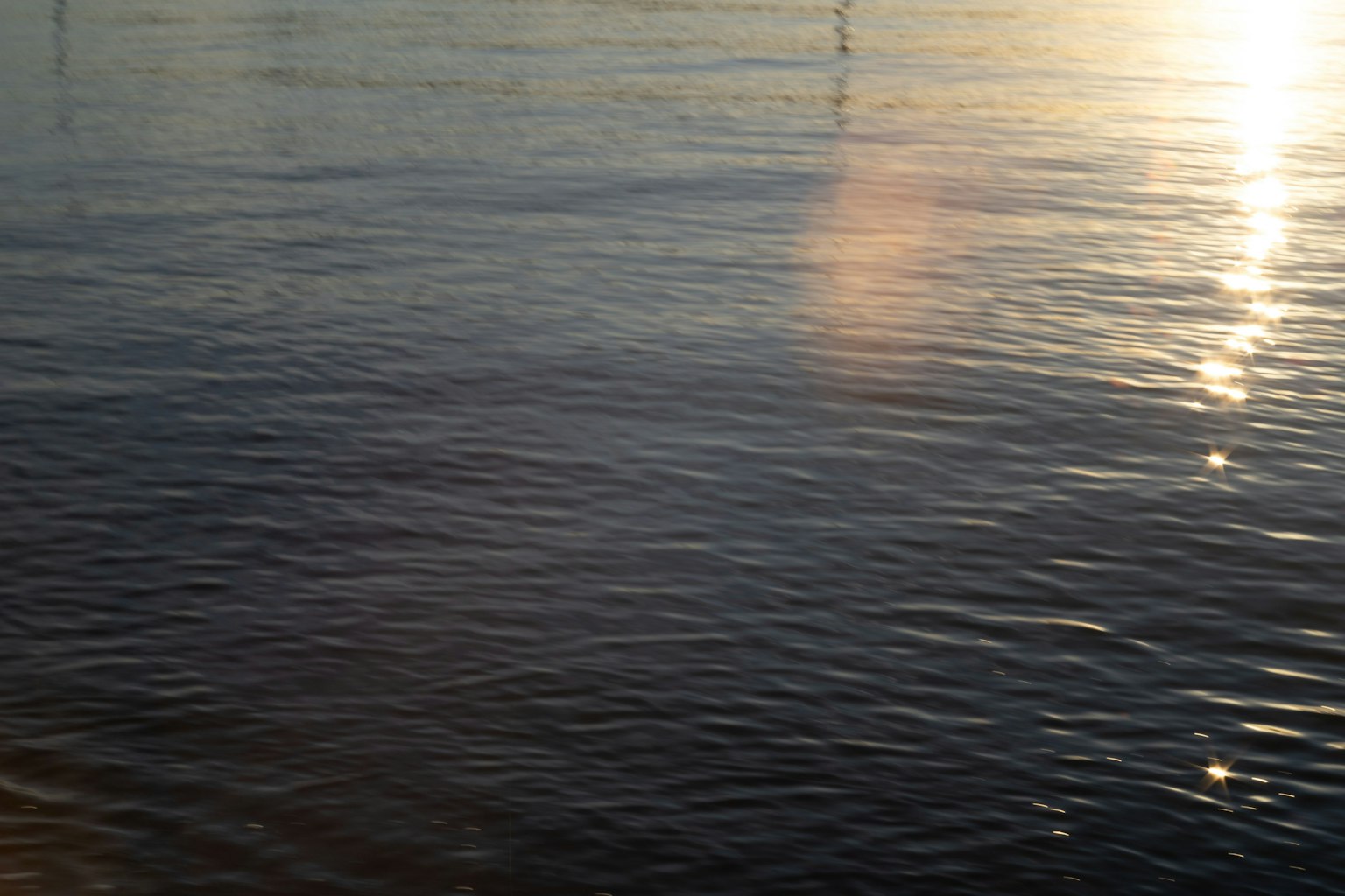 Superficie de agua tranquila reflejando luz