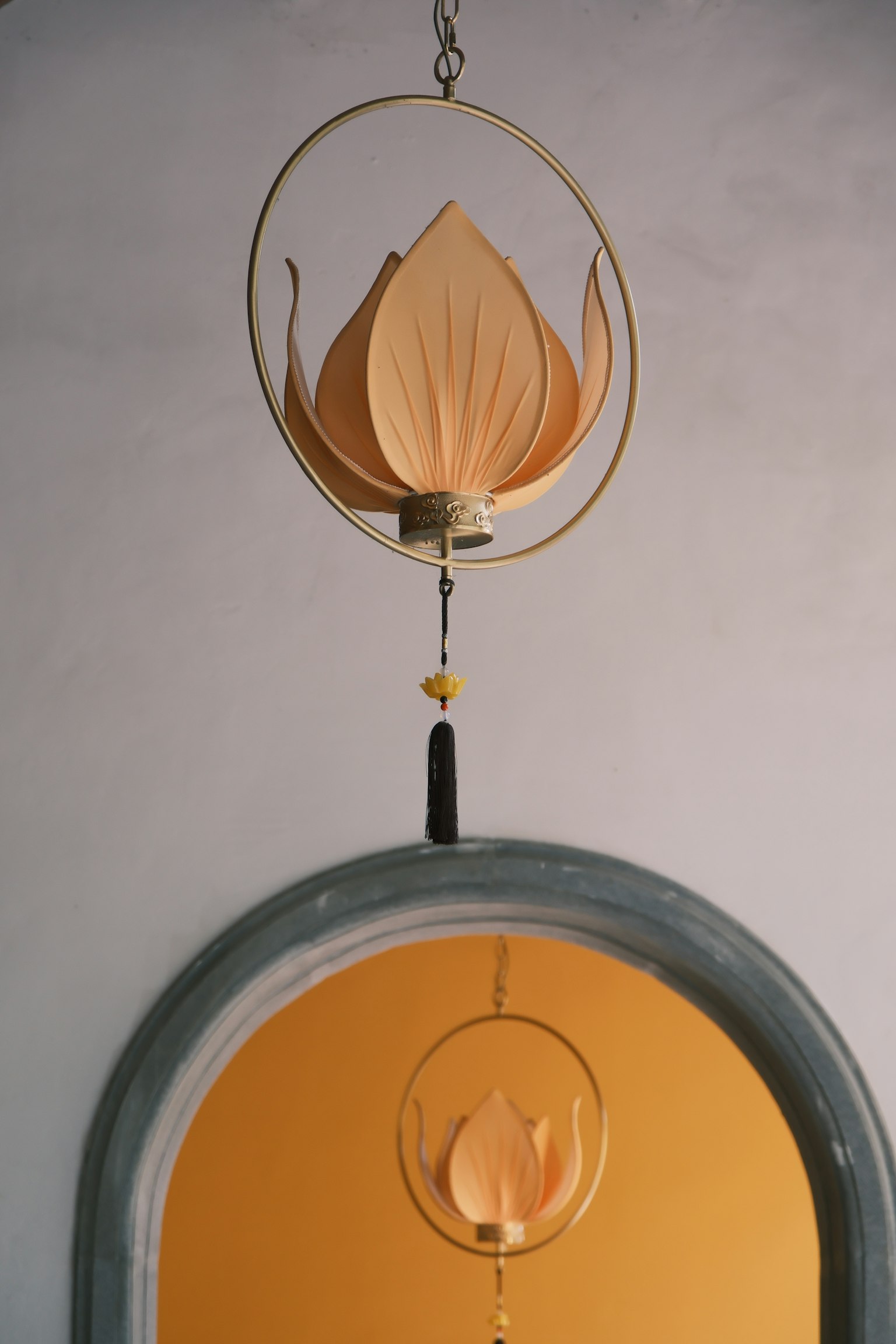 Decorazione a forma di fiore di loto appesa sopra una porta arancione con un telaio circolare