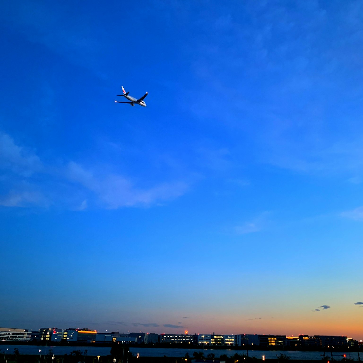 Ein Flugzeug fliegt im blauen Himmel während des Sonnenuntergangs