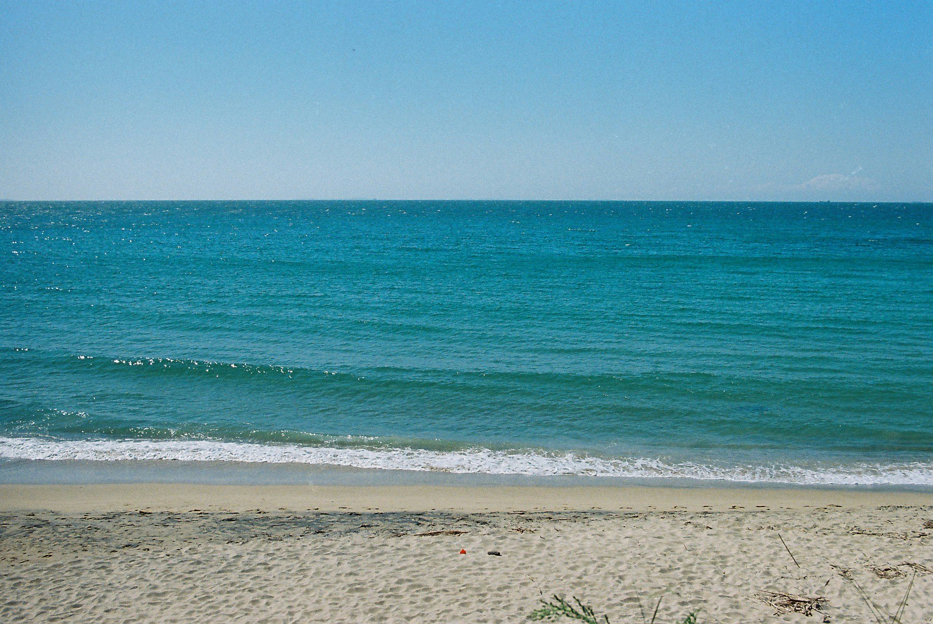 青い海と穏やかな波が広がる砂浜の風景