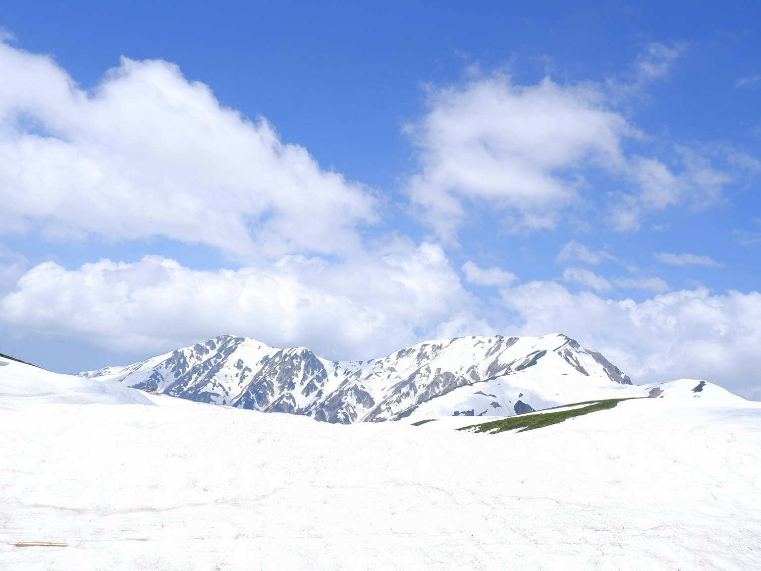 Snow-covered mountains under a bright blue sky
