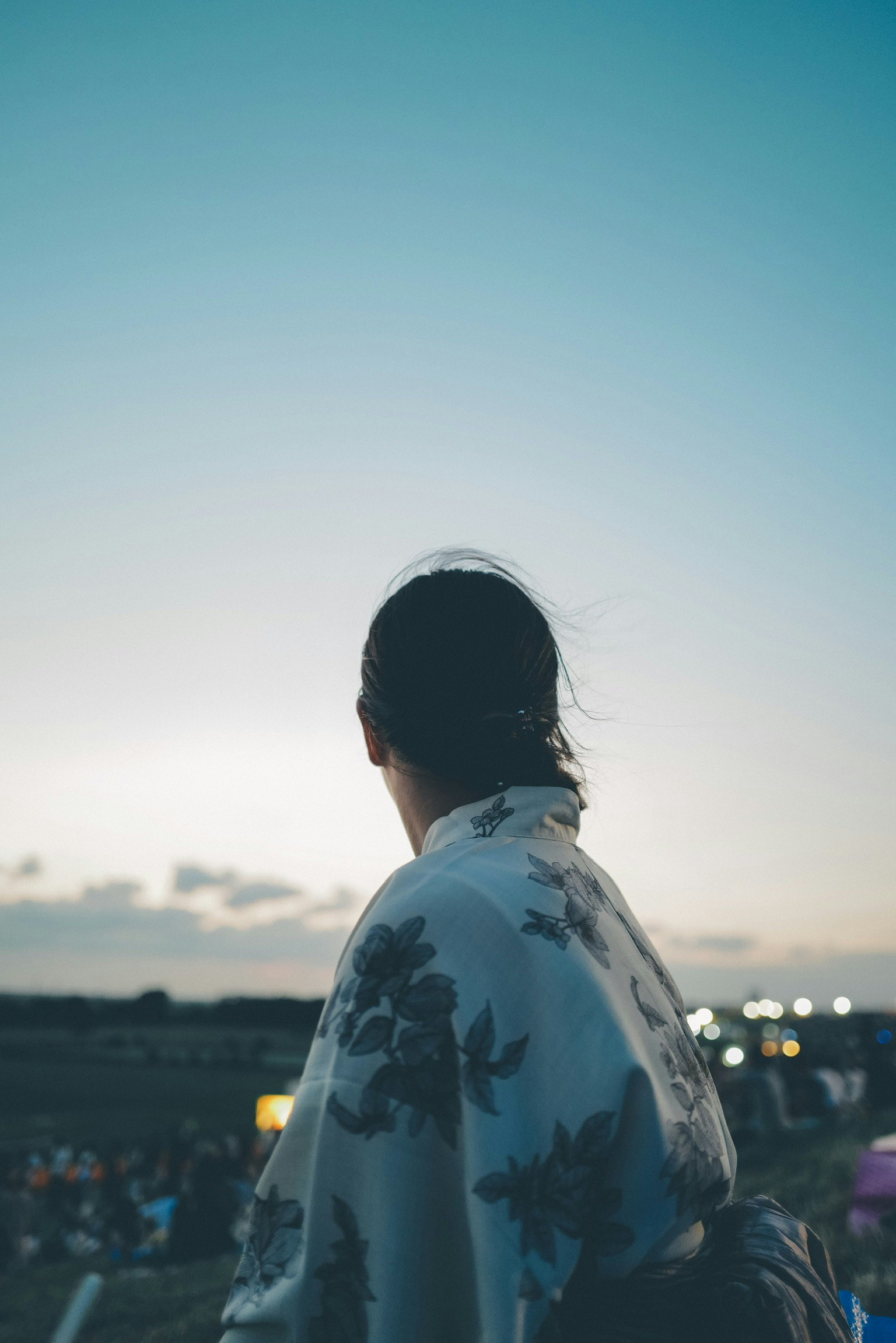 Una mujer con kimono mirando el cielo al atardecer