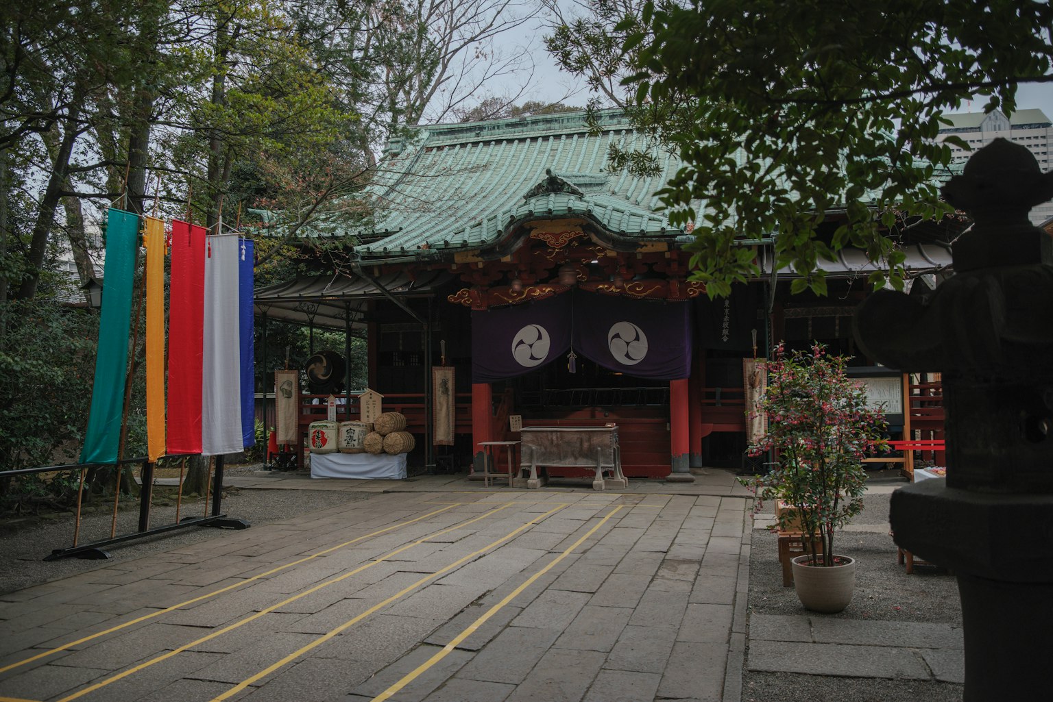녹색 지붕을 가진 신사 건물과 앞에 서 있는 다채로운 기