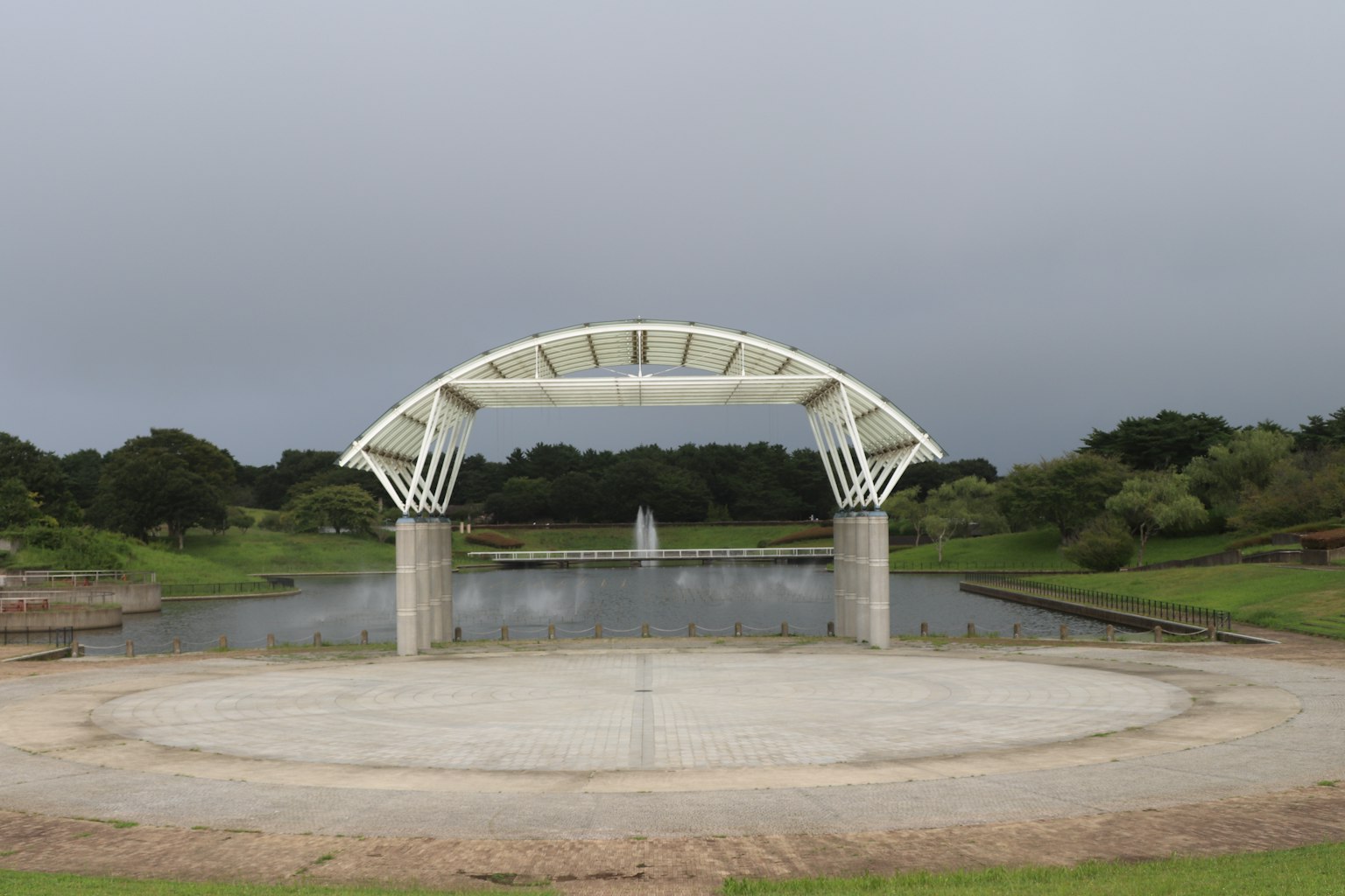 Pabellón blanco en arco que da a un estanque sereno