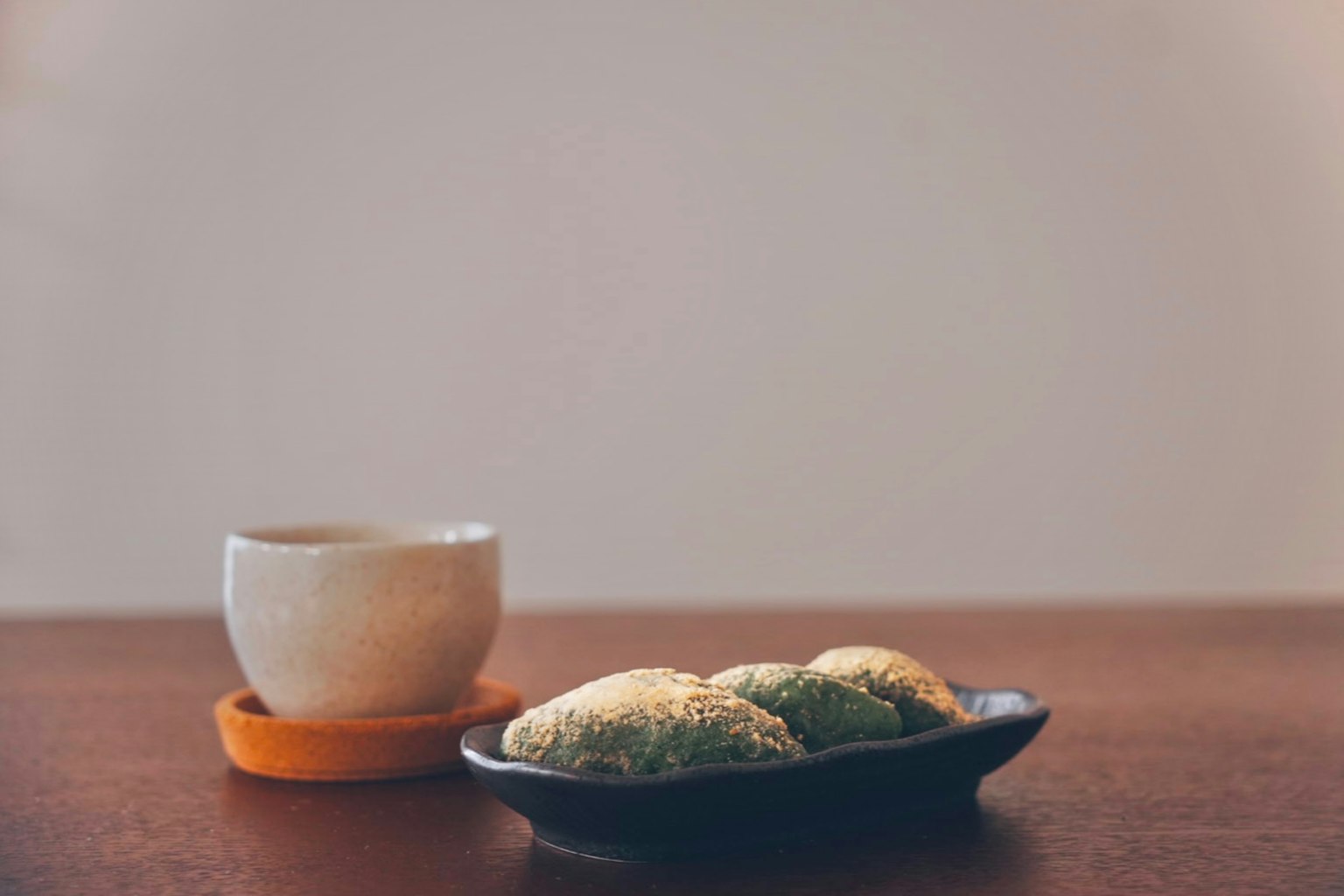 一杯茶和一盘日本甜点放在木桌上