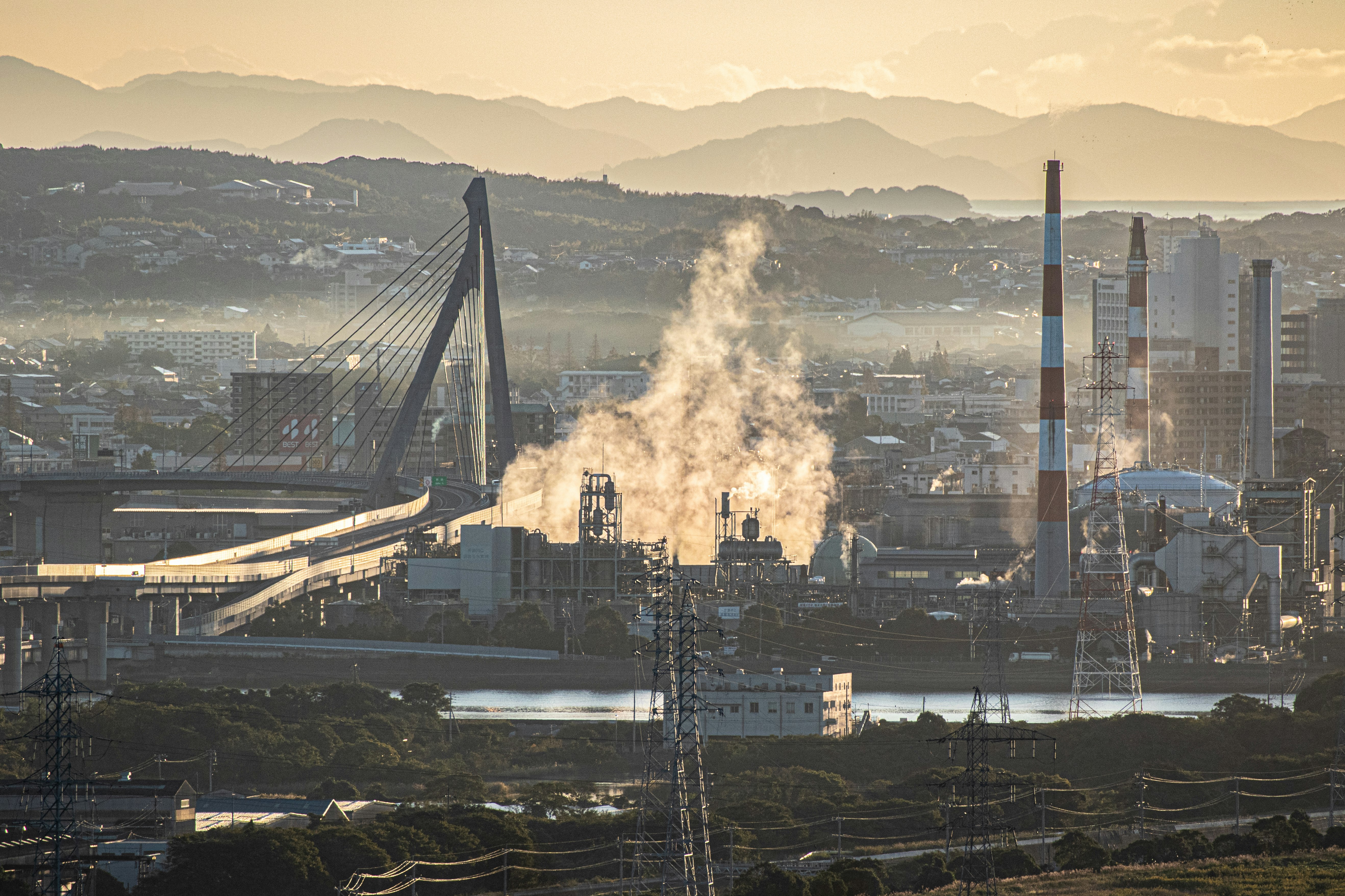 paisaje industrial con chimeneas expulsando vapor al atardecer