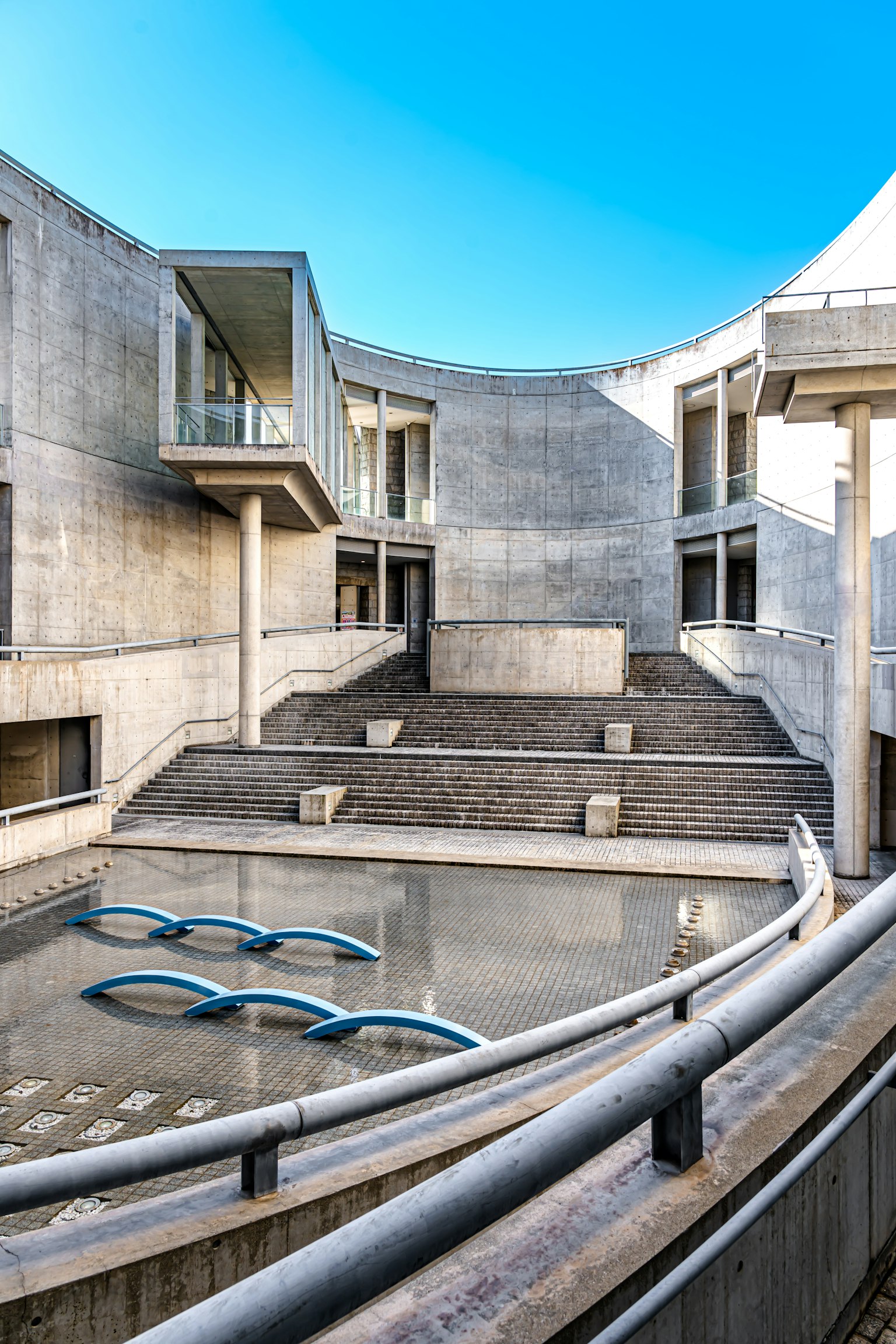 Modern architectural space featuring concrete structures and a water pool