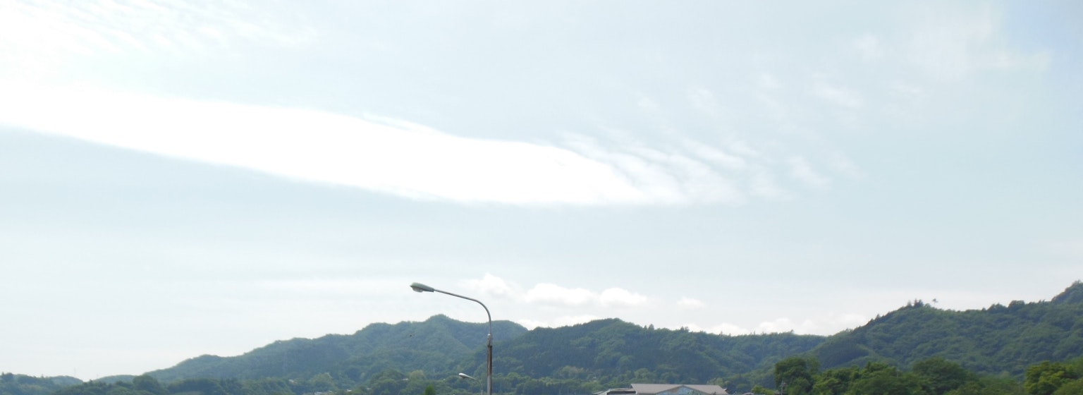 Pemandangan pegunungan di bawah langit biru dengan awan