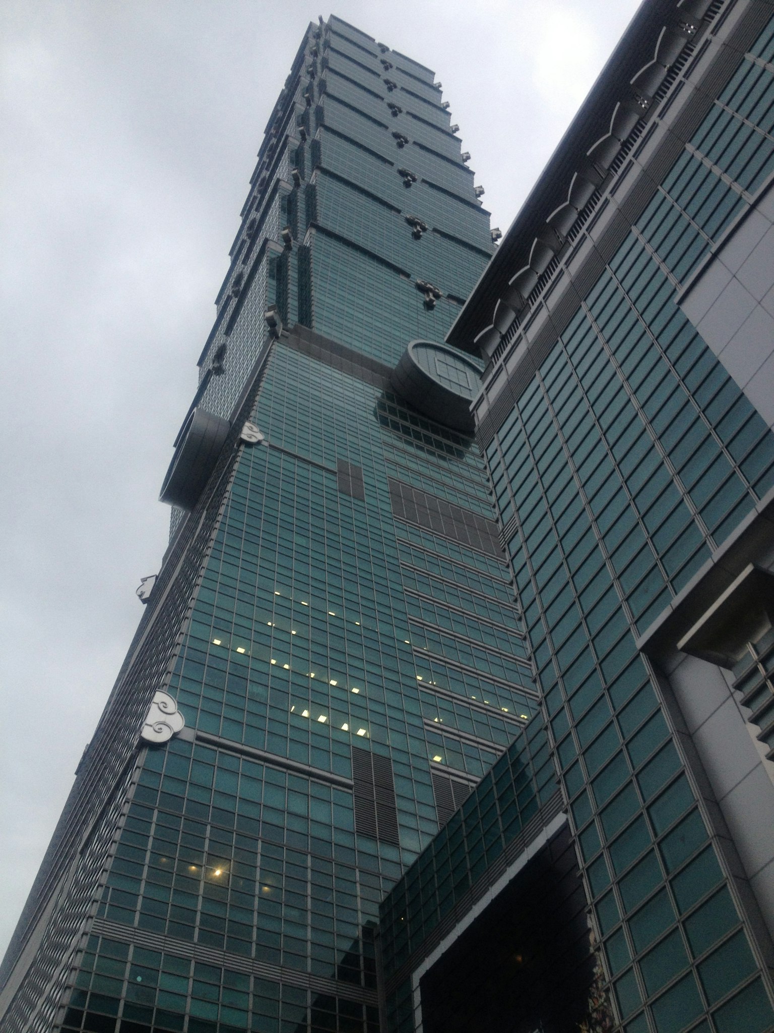 Immagine di Taipei 101 che mostra il grattacielo distintivo da un'angolazione bassa evidenziando la sua facciata in vetro