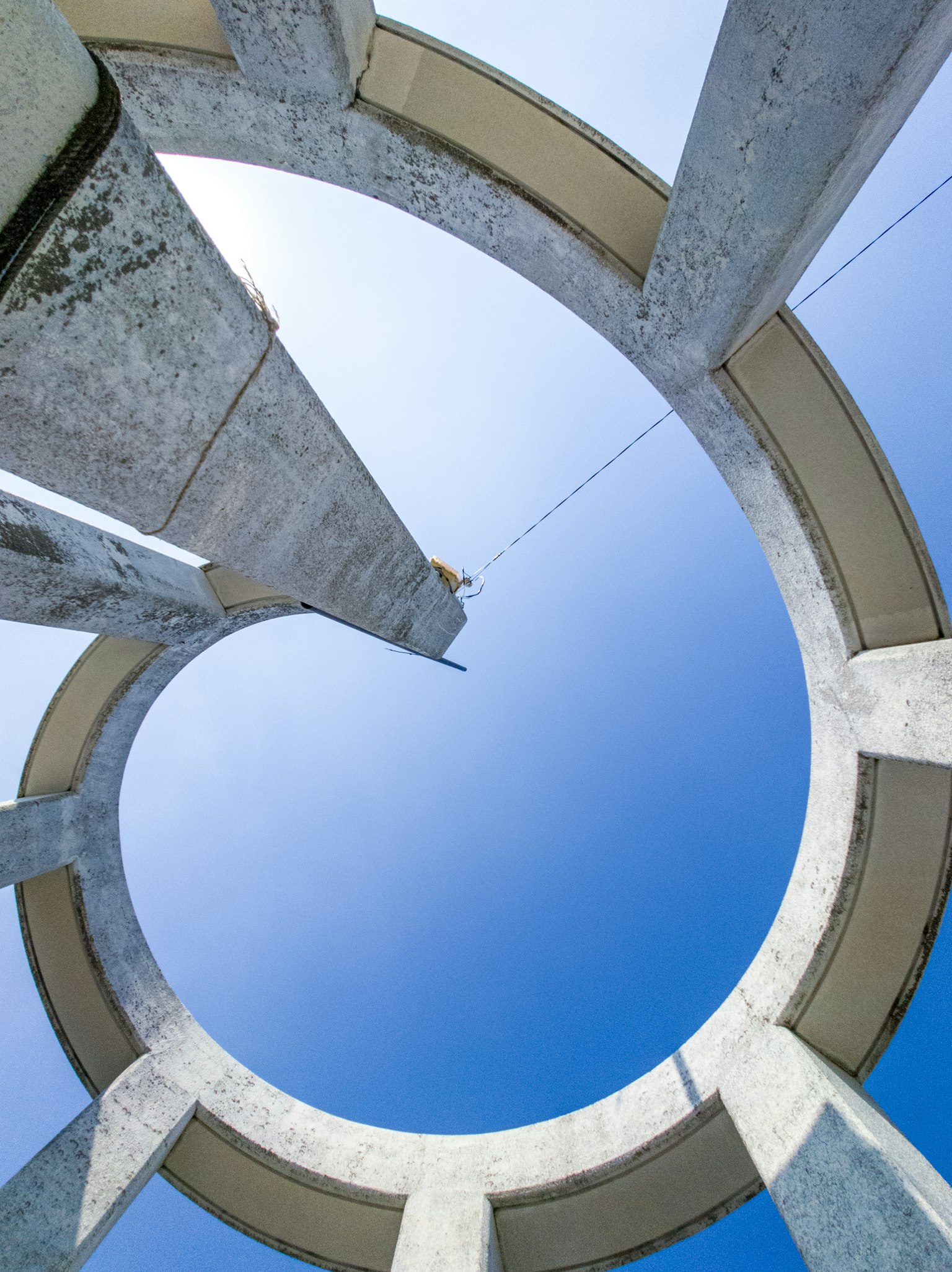 Vue d'en bas d'une structure circulaire en béton contre un ciel bleu