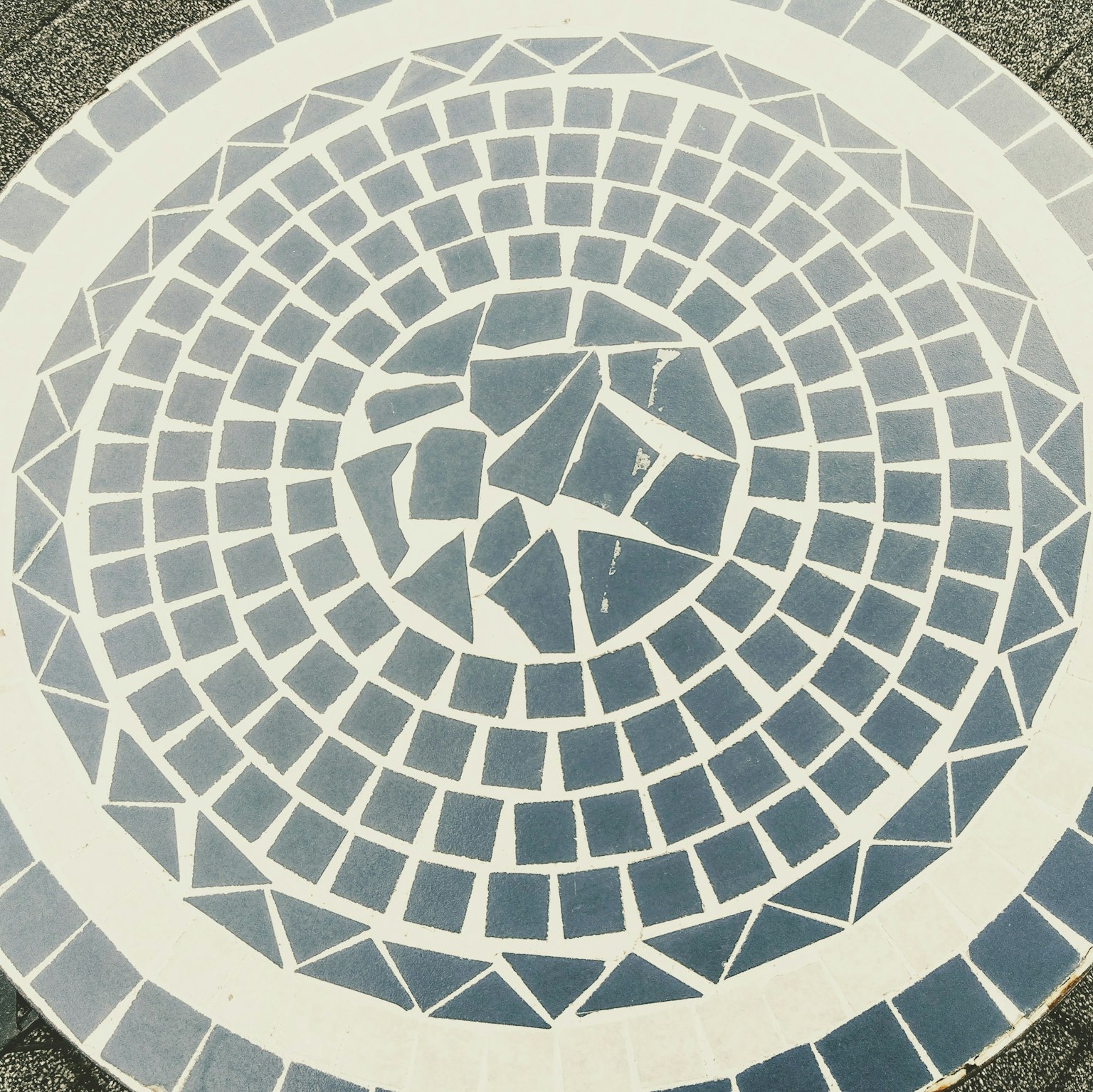 Circular mosaic pattern with black and white tiles