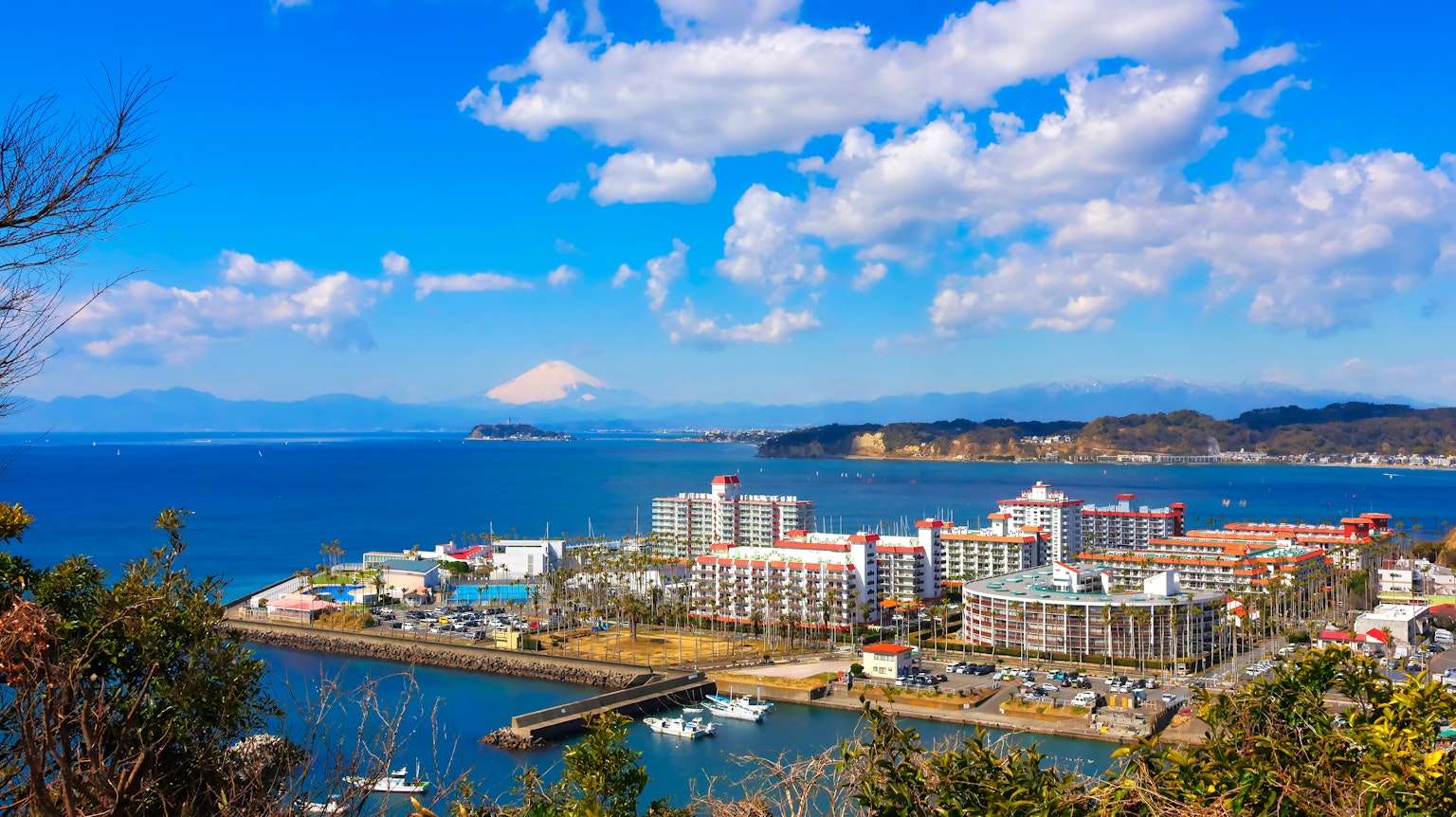 Scenic coastal view with modern buildings and Mount Fuji in the distance